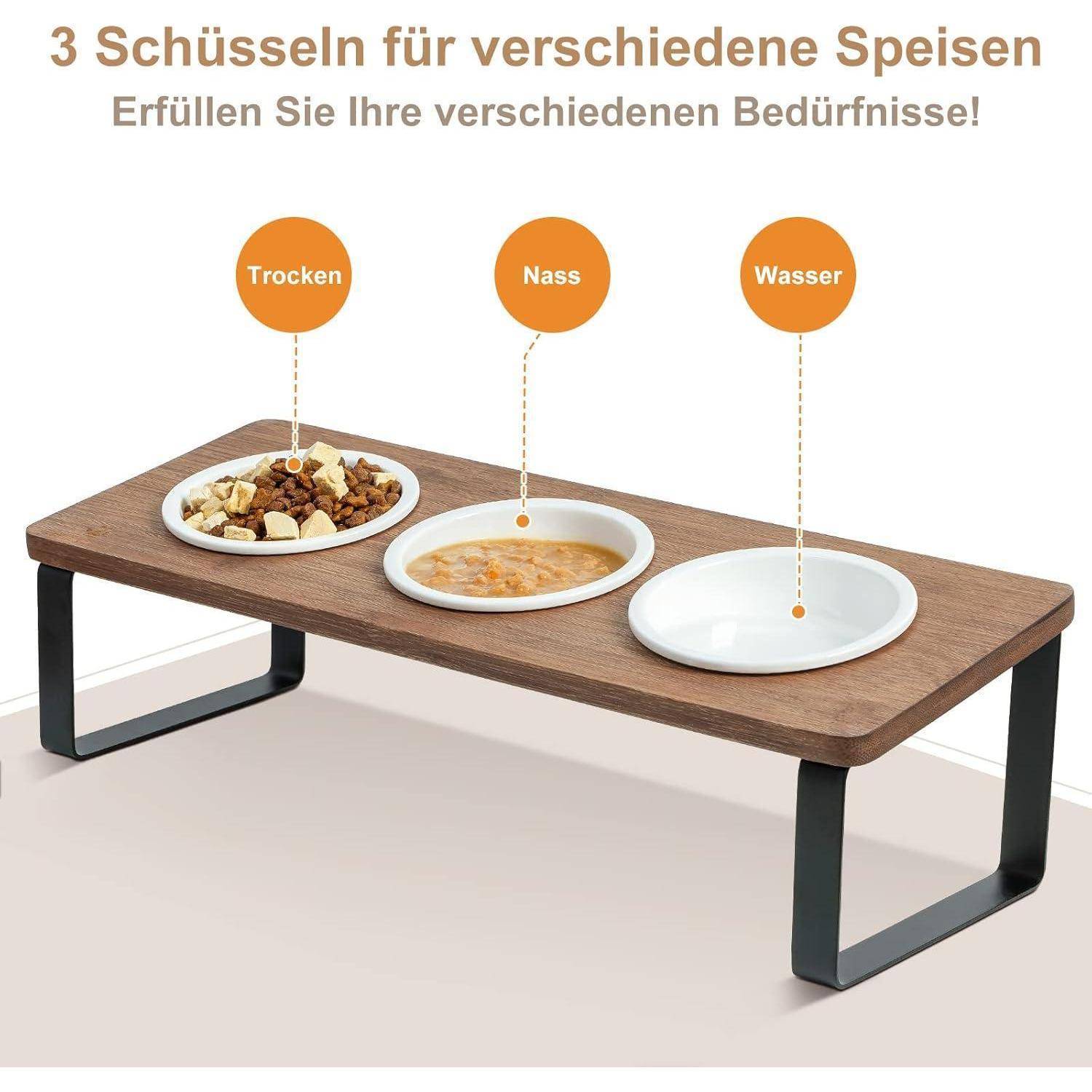 Eine Holz-Haustier-Futterstelle mit drei beschrifteten Schüsseln: 'Trocken' für Trockenfutter, 'Nass' für Nassfutter und 'Wasser' für Wasser.