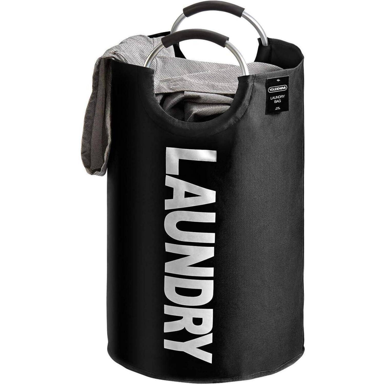 Schwarzer Wäschekorb mit Griffen und dem Wort 'LAUNDRY' in fetten weißen Buchstaben an der Seite. Ein graues Tuch ist lässig über den Rand geworfen.