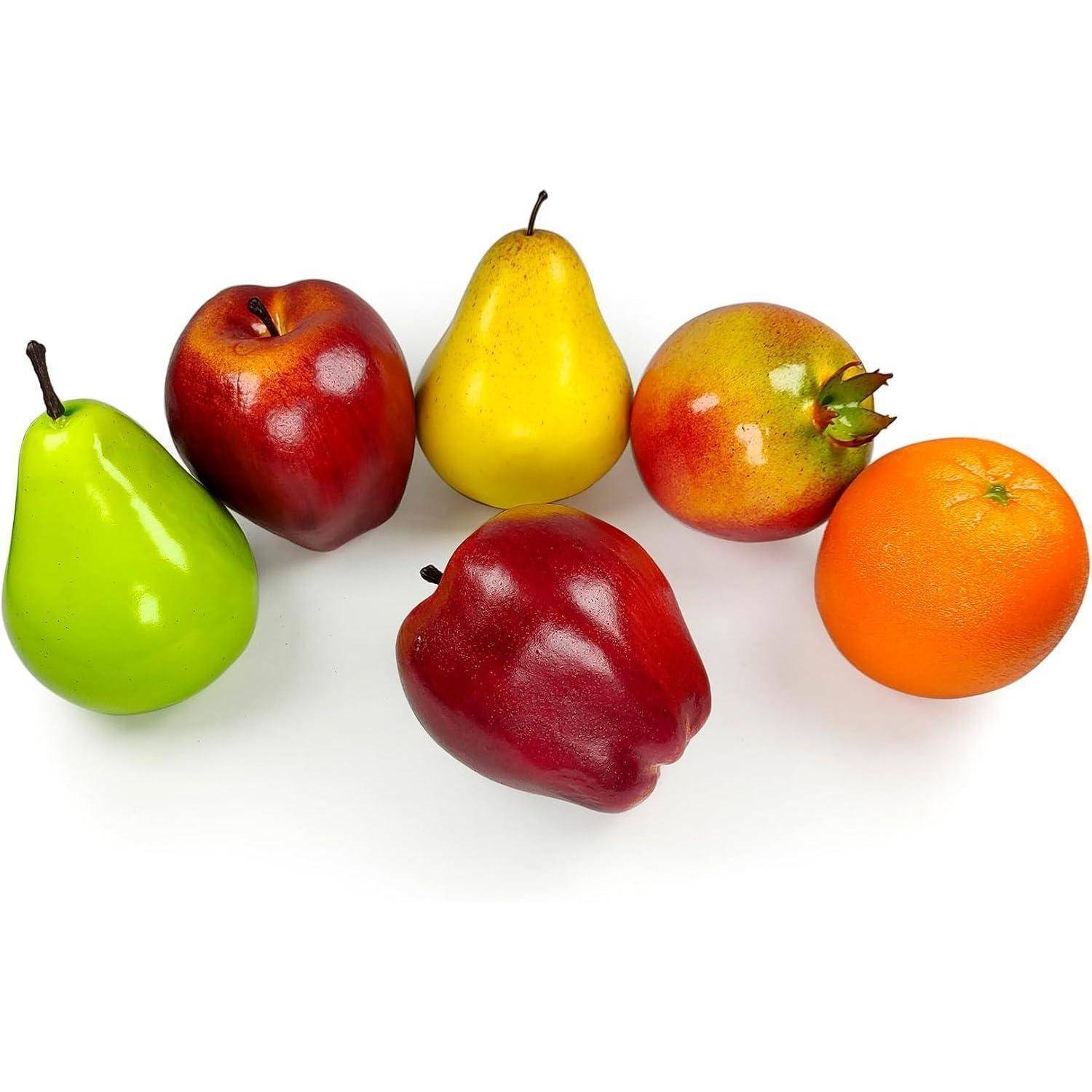 Eine Auswahl an Früchten, darunter eine grüne Birne, rote Äpfel, eine gelbe Birne, ein Granatapfel und eine Orange, sind auf einem weißen Hintergrund angeordnet.