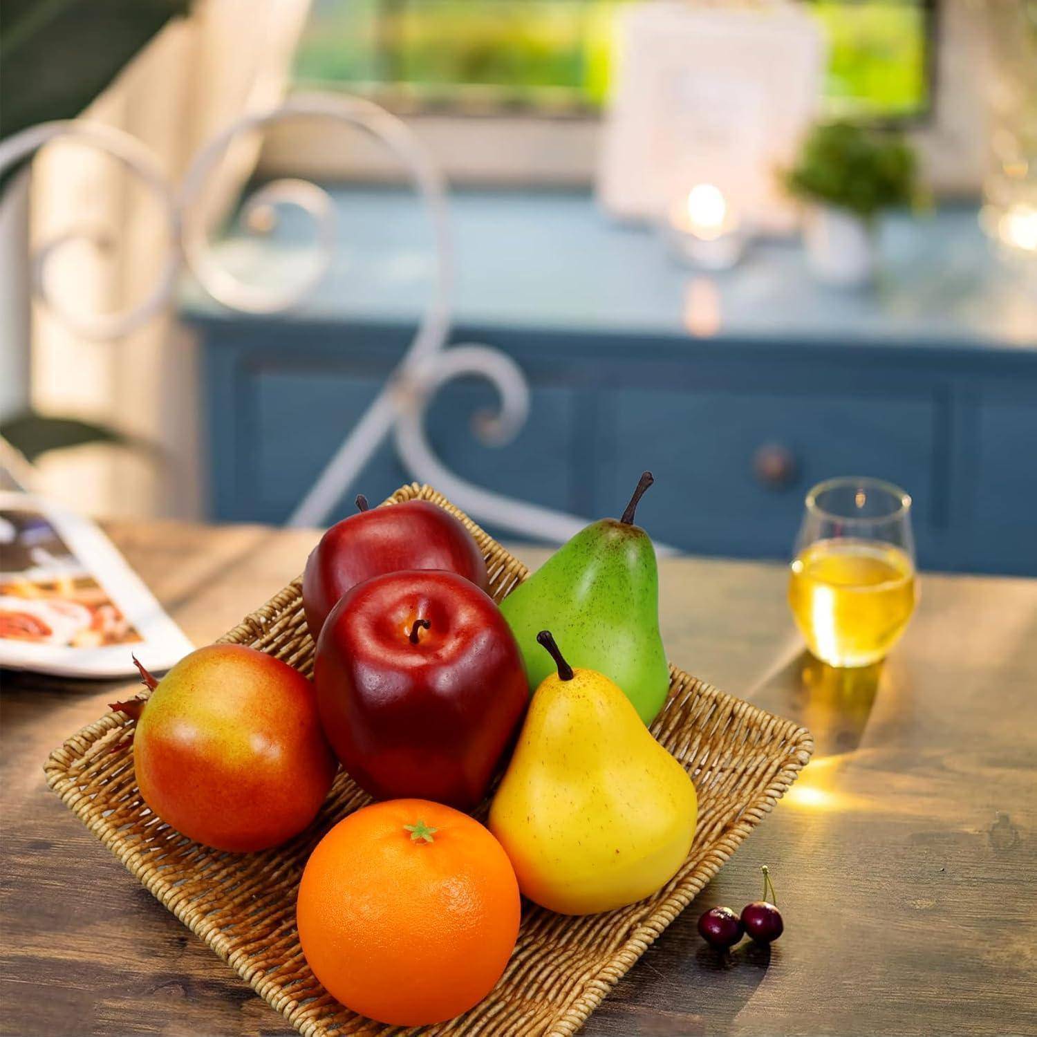 Ein geflochtener Korb enthält einen Apfel, einen roten Apfel, eine Birne, eine Orange und eine gelbe Birne auf einem Tisch. Ein Glas Saft und Kirschen befinden sich daneben.