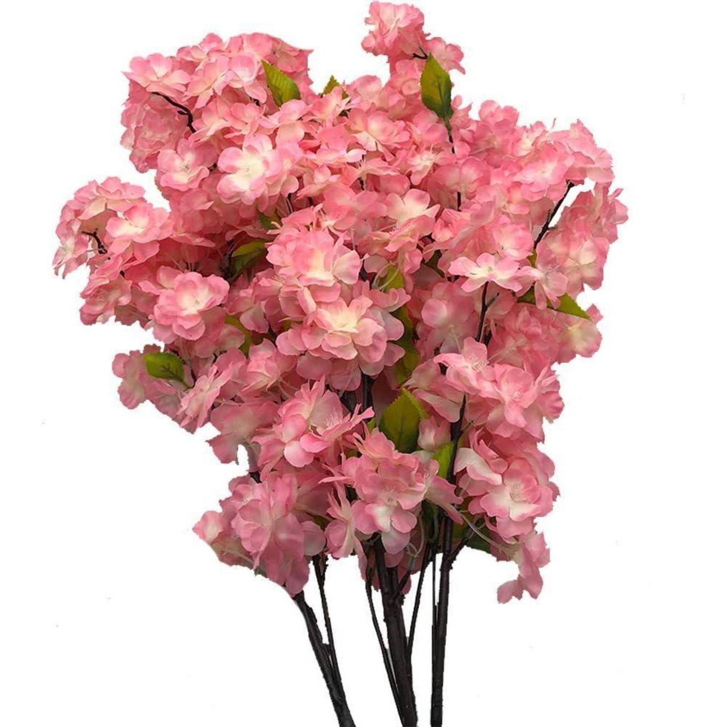 Ein Strauß aus künstlichen Kirschblütenzweigen mit rosa Blüten und grünen Blättern vor einem schlichten weißen Hintergrund.