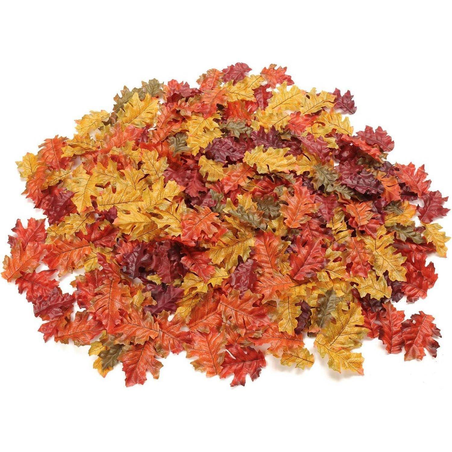 Ein Haufen bunter künstlicher Herbstblätter in Rottönen, Orange, Gelb und Grün, die eine Herbststimmung heraufbeschwören.