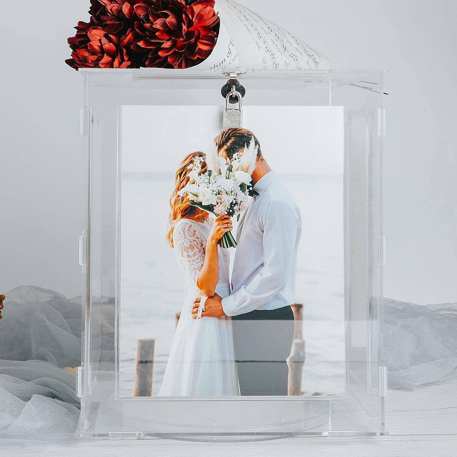 Ein Hochzeitsfoto eines Paares am Meer, das die Braut mit einem Strauß weißer Blumen zeigt, mit dekorativen roten Blumen darüber.