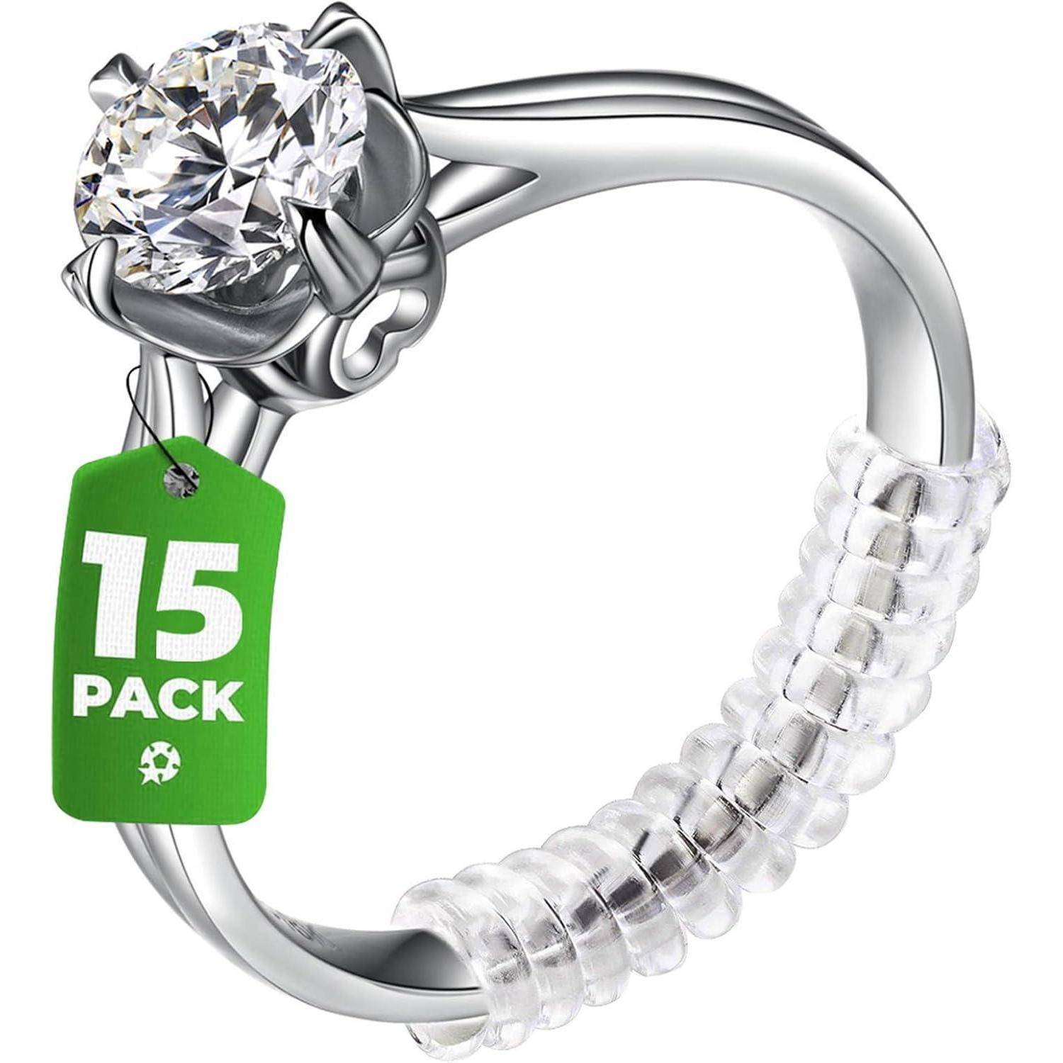 Ein silberner Ring mit einem großen Diamanten und einem grünen Anhänger, auf dem '15 Pack' steht. Der Ring hat eine gewundene Struktur am Ringband.