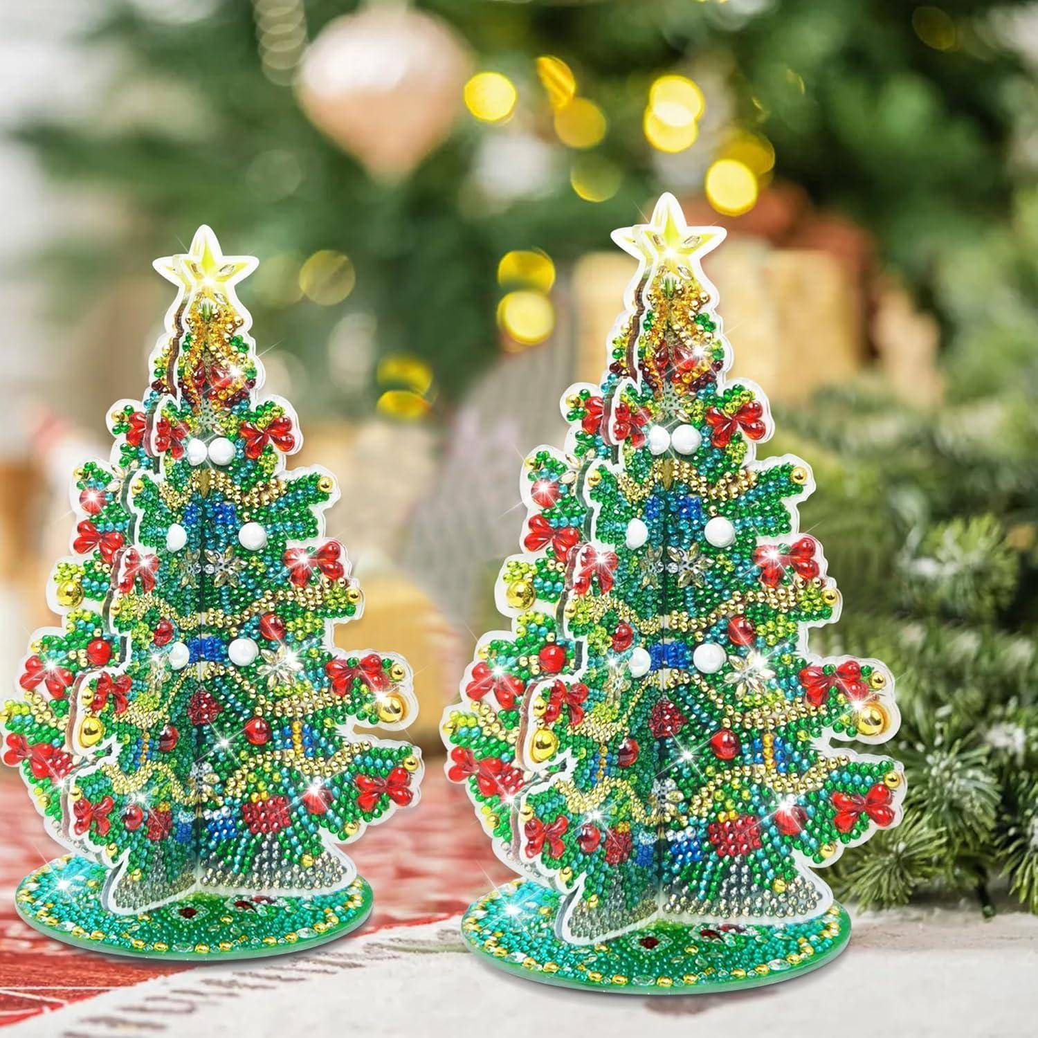 Zwei dekorative Weihnachtsbäume, geschmückt mit bunten Perlen und Pailletten, versehen mit Sternenspitzen, vor einem festlichen, unscharfen Hintergrund.