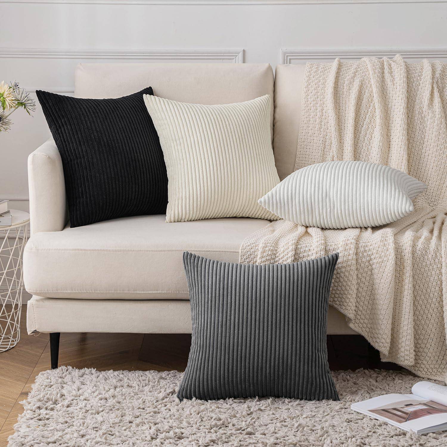 Eine gemütliche beige Couch mit strukturierten Kissen in Schwarz, Beige und Creme, eine gewebte Decke an der Seite drapiert, auf einem weichen Teppich.