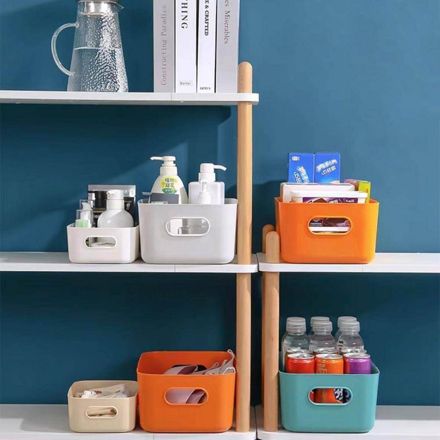 Regale mit verschiedenen sortierten Gegenständen: ein Wasserkrug, Bücher, Toilettenartikel, Reinigungsmittel, Snacks und Wasserflaschen in farbigen Kisten.