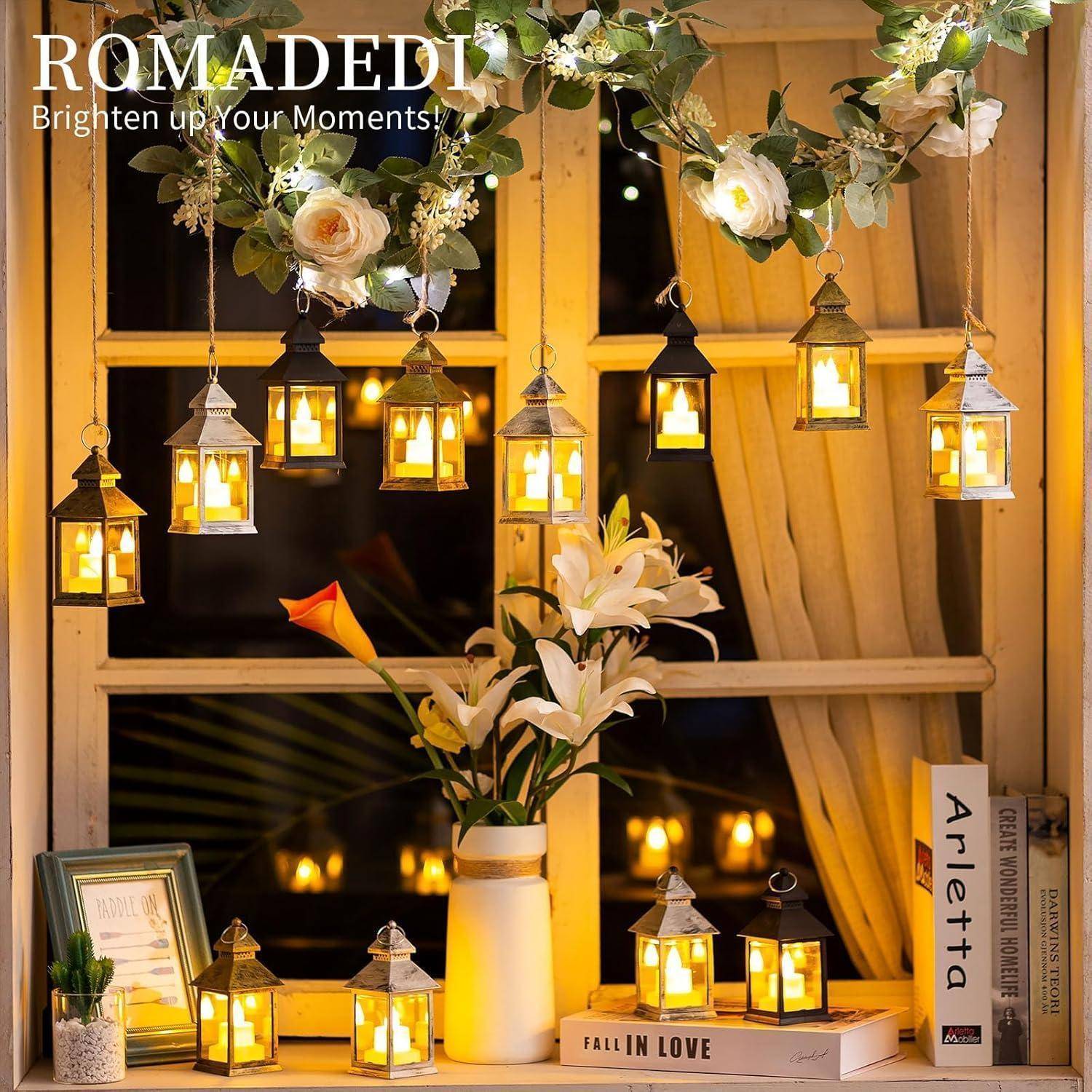 Eine Schaufenstergestaltung mit hängenden Laternen und Blumen, die eine gemütliche und dekorative Anordnung mit warmem Lichtschein und einer Vase mit weißen Lilien präsentiert.