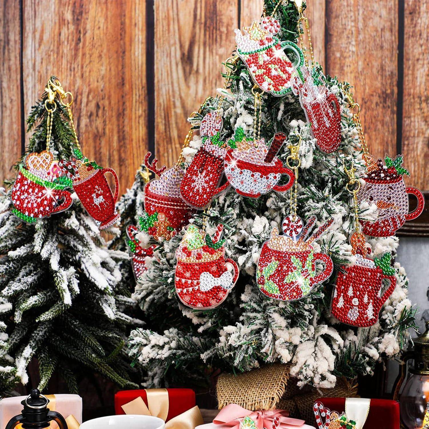 Ein mit Schnee bestäubter Weihnachtsbaum, geschmückt mit hell dekorierten, bunten Tassen-Anhängern. Mehrere weihnachtlich gestaltete Tassen sind darunter sichtbar.