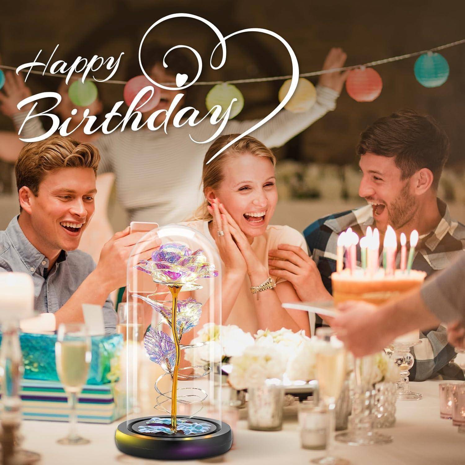 Menschen, die Geburtstag feiern, mit einer 'Alles Gute zum Geburtstag'-Schrift. Eine Frau lächelt, umgeben von Freunden. Eine Torte mit Kerzen ist im Vordergrund.