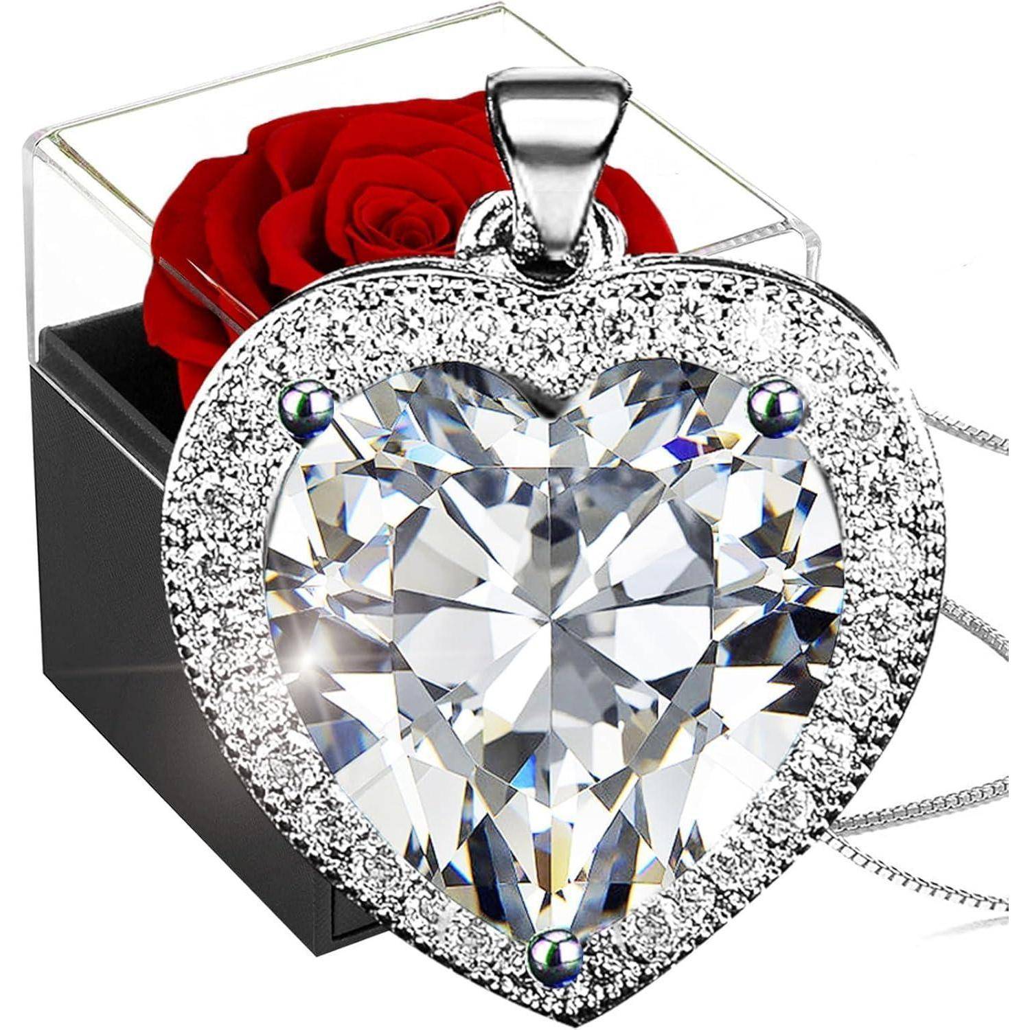Herzförmiger Kristallanhänger mit diamantähnlichem Rand, vor einer schwarzen Box mit einer einzelnen roten Rose.