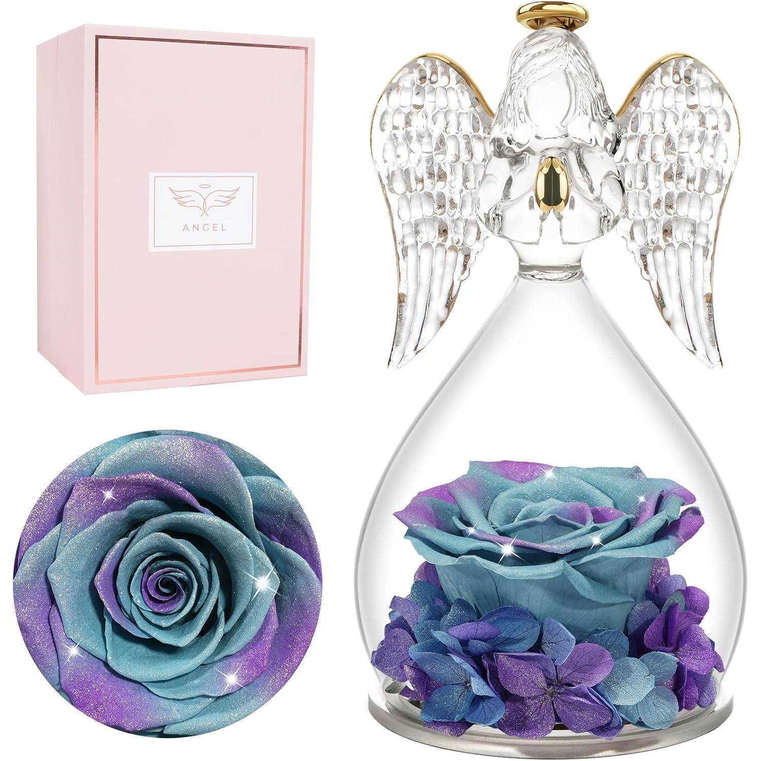 Glasengel-Figur mit schillernden Flügeln umschließt eine blau und lila konservierte Rose und Hortensie. Rosa Geschenkbox mit der Aufschrift ‚Engel'.
