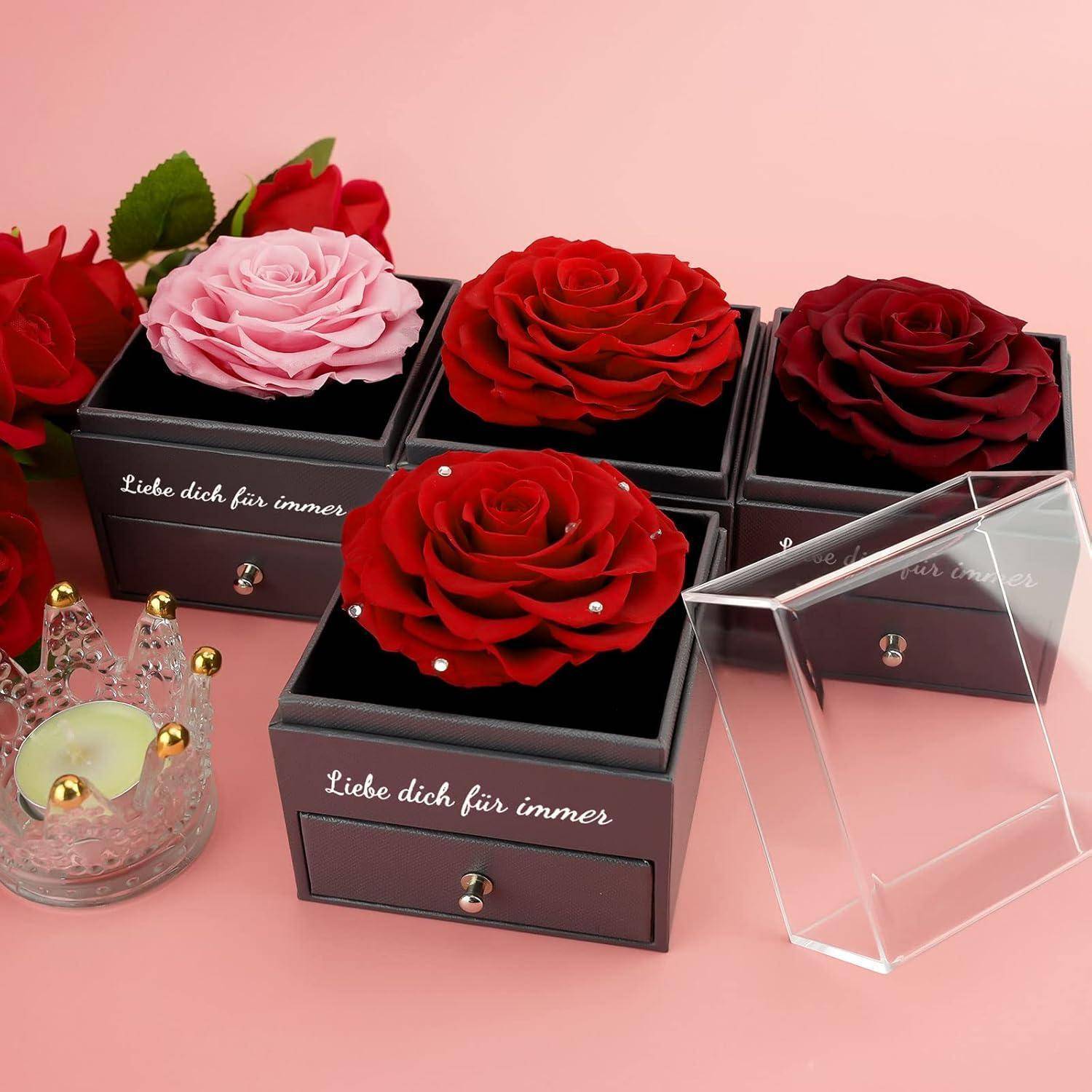 Ein Set aus roten und rosa Rosen in schwarzen Boxen mit deutschem Text 'Liebe dich für immer' auf einem rosa Hintergrund.