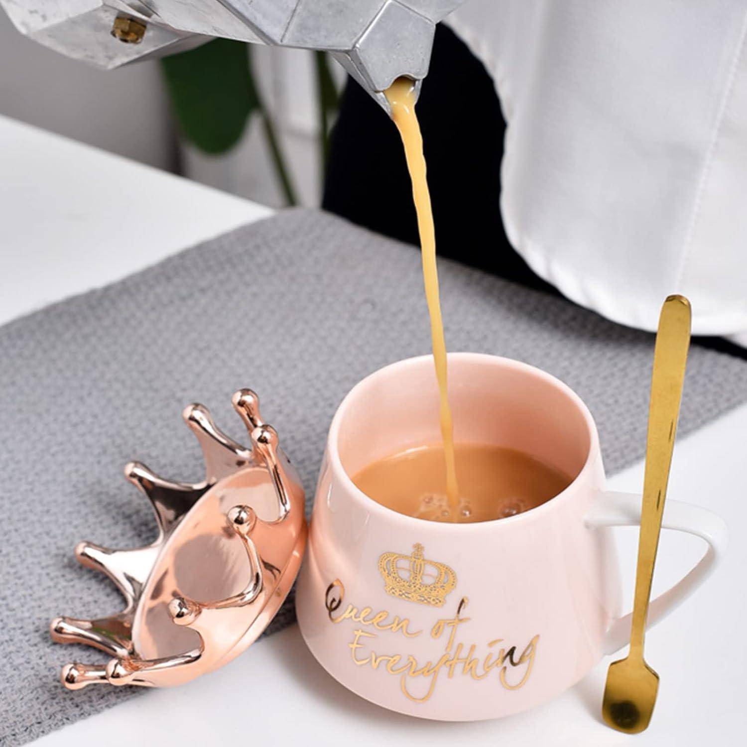 Eine goldfarbene Flüssigkeit wird in eine weiße Tasse mit goldener Aufschrift 