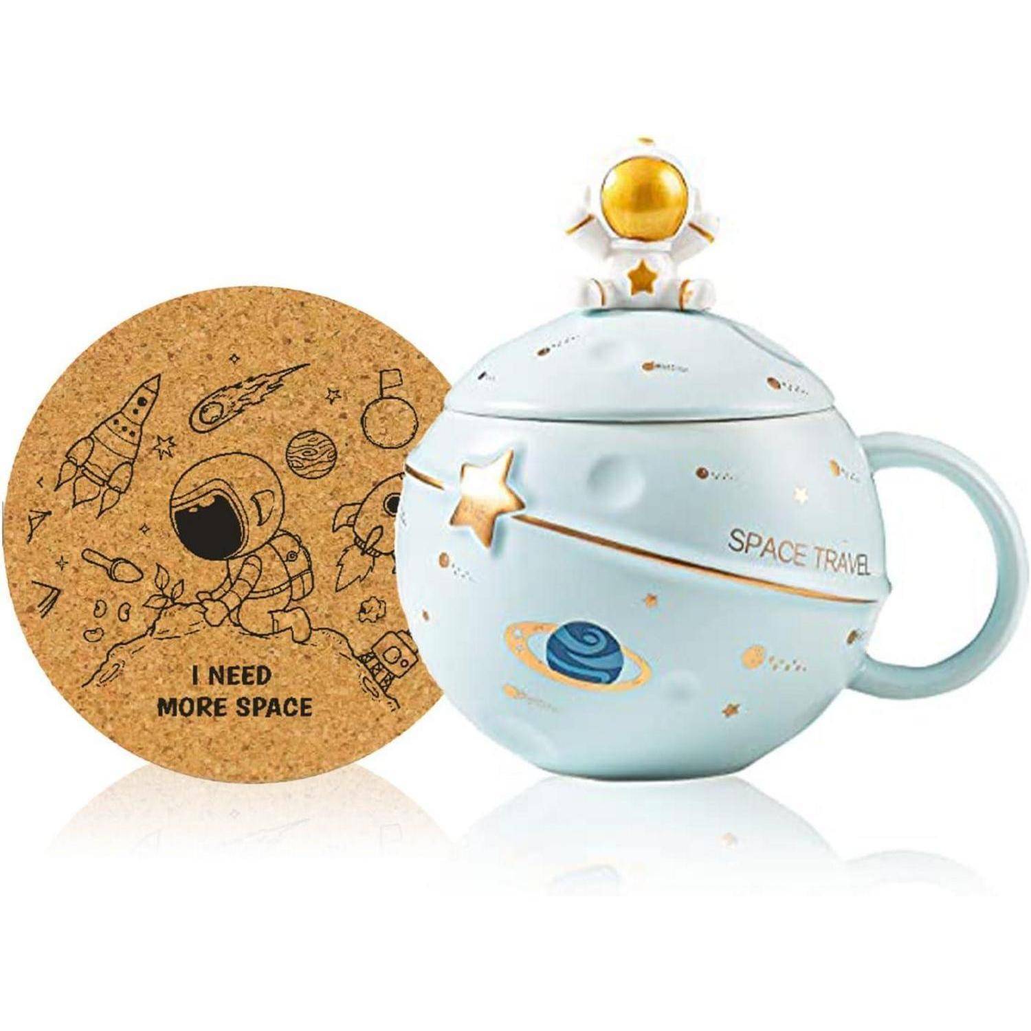 Eine runde Tasse mit Weltraum-Thema, auf deren Deckel ein Astronaut sitzt und die mit Planetendesigns verziert ist. Ein Untersetzer trägt die Aufschrift ‚Ich brauche mehr Platz' mit Weltraum-Illustrationen.
