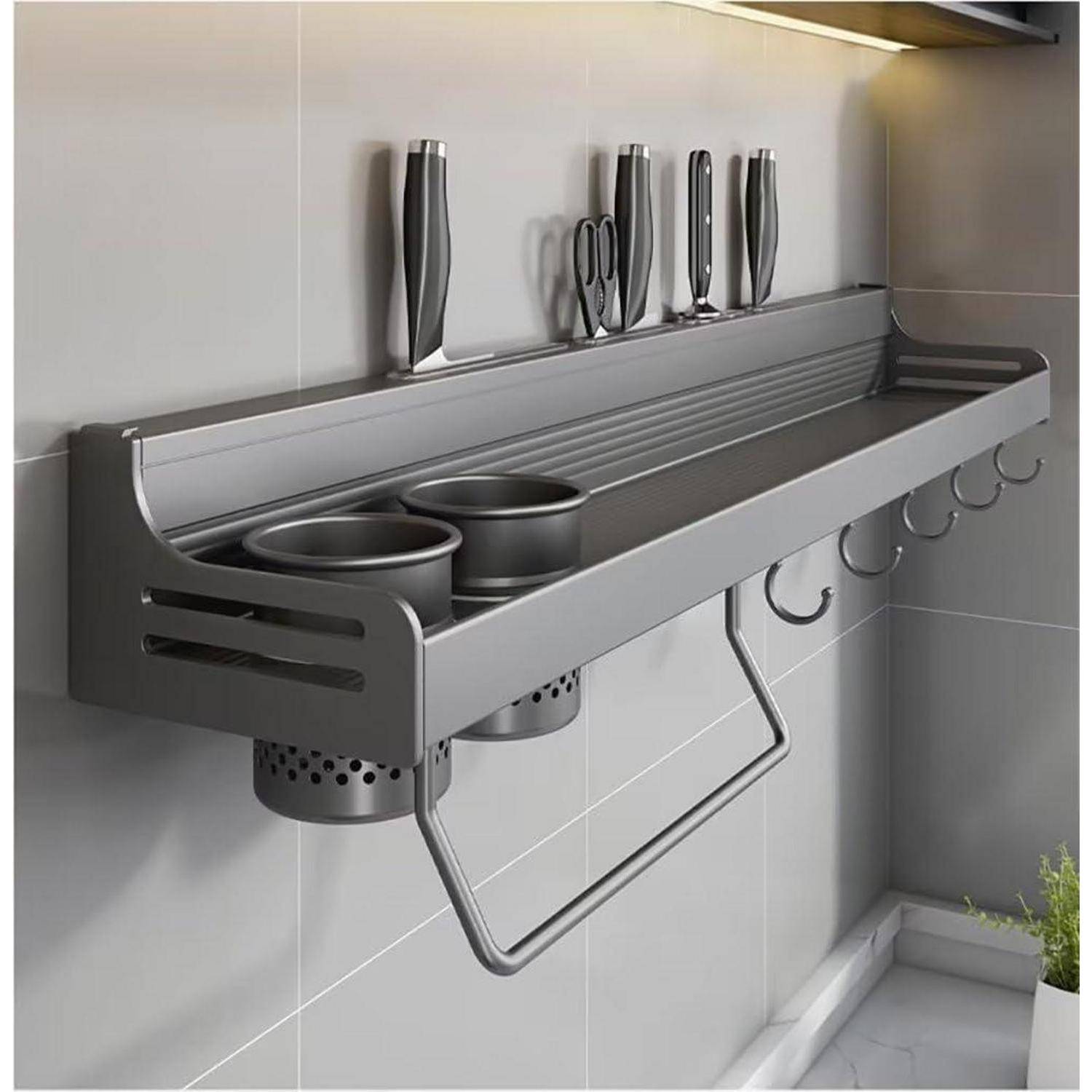 Wandmontierte Küchenablage mit Schlitzen für Messer, Fächern für Utensilien und Haken zum Aufhängen. Edelstahl-Finish an gefliester Wand.