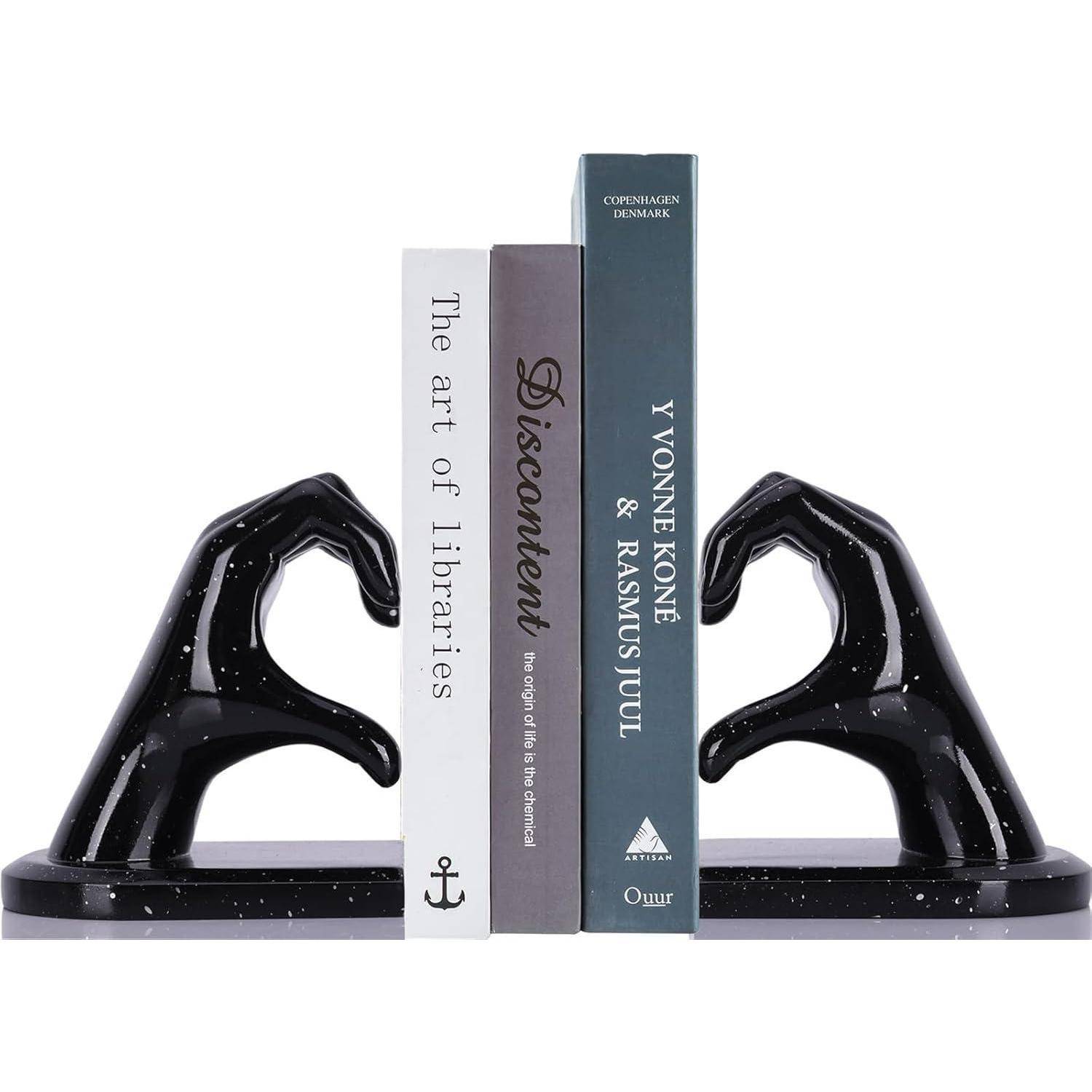Bücher, die durch schwarze handförmige Buchstützen aufrecht gehalten werden. Sichtbare Titel: 