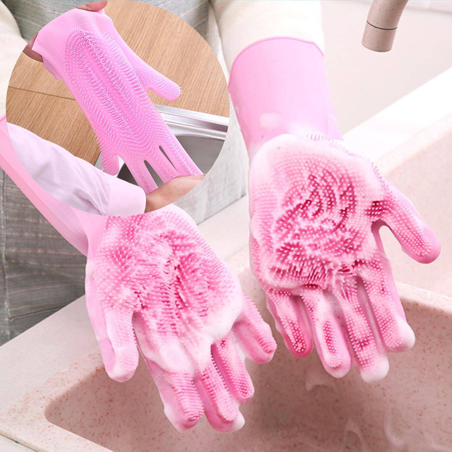 Rosa Silikonreinigungshandschuhe mit Borsten, die zum Abwaschen verwendet werden. Nahaufnahme zeigt, wie die Handschuhe unter einem Wasserhahn abgespült werden.