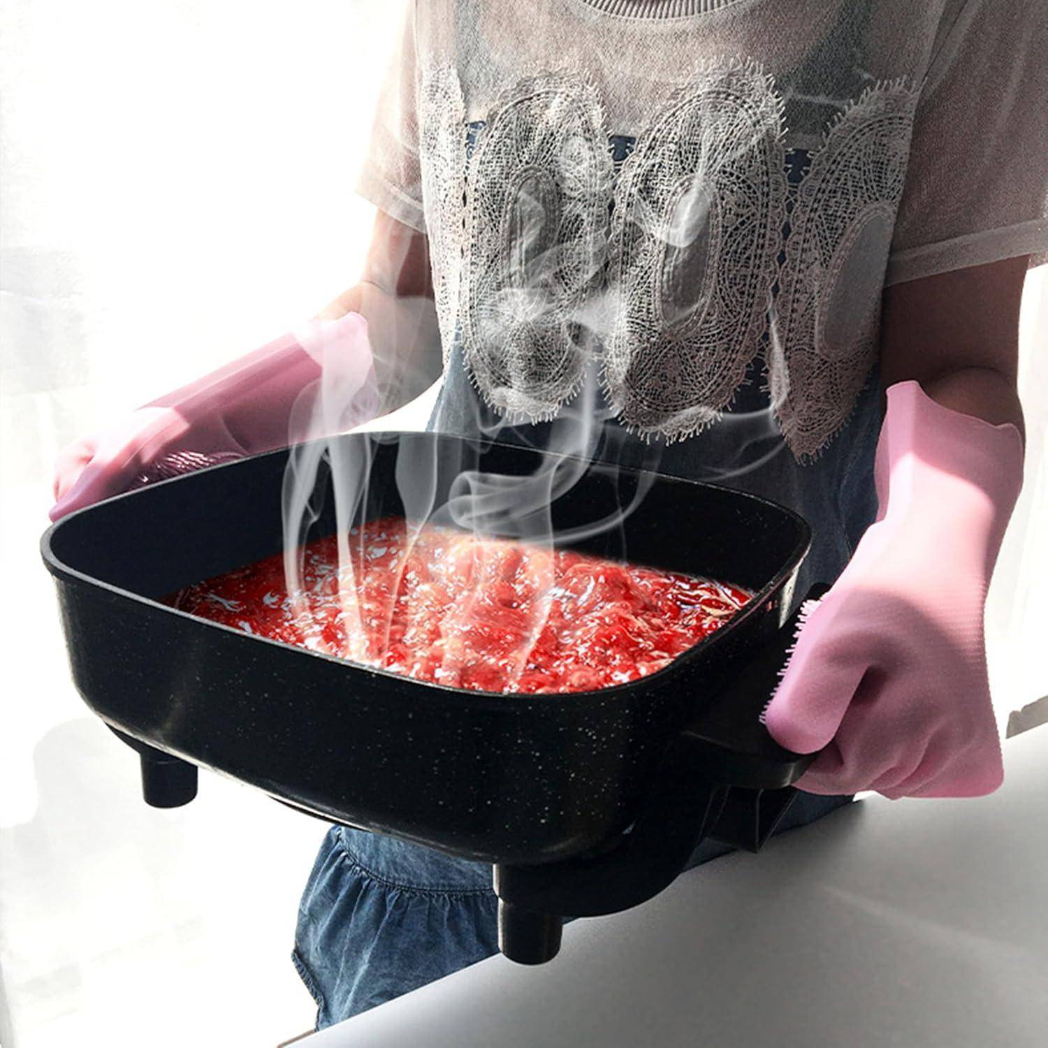 Eine Person mit rosa Handschuhen hält einen dampfenden schwarzen Topf mit roter Flüssigkeit, was einen heißen Kochvorgang andeutet.