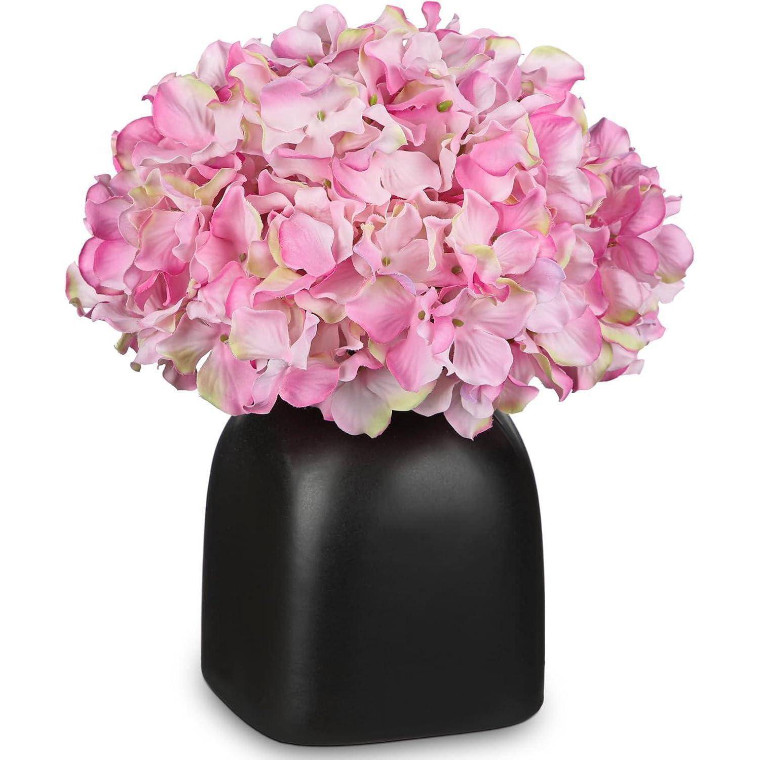 Ein Strauß rosa Hortensien in einer eleganten schwarzen Quadratvase, der weiche Blütenblätter und subtile Farbverläufe präsentiert und so ein stilvolles Centerpiece schafft.