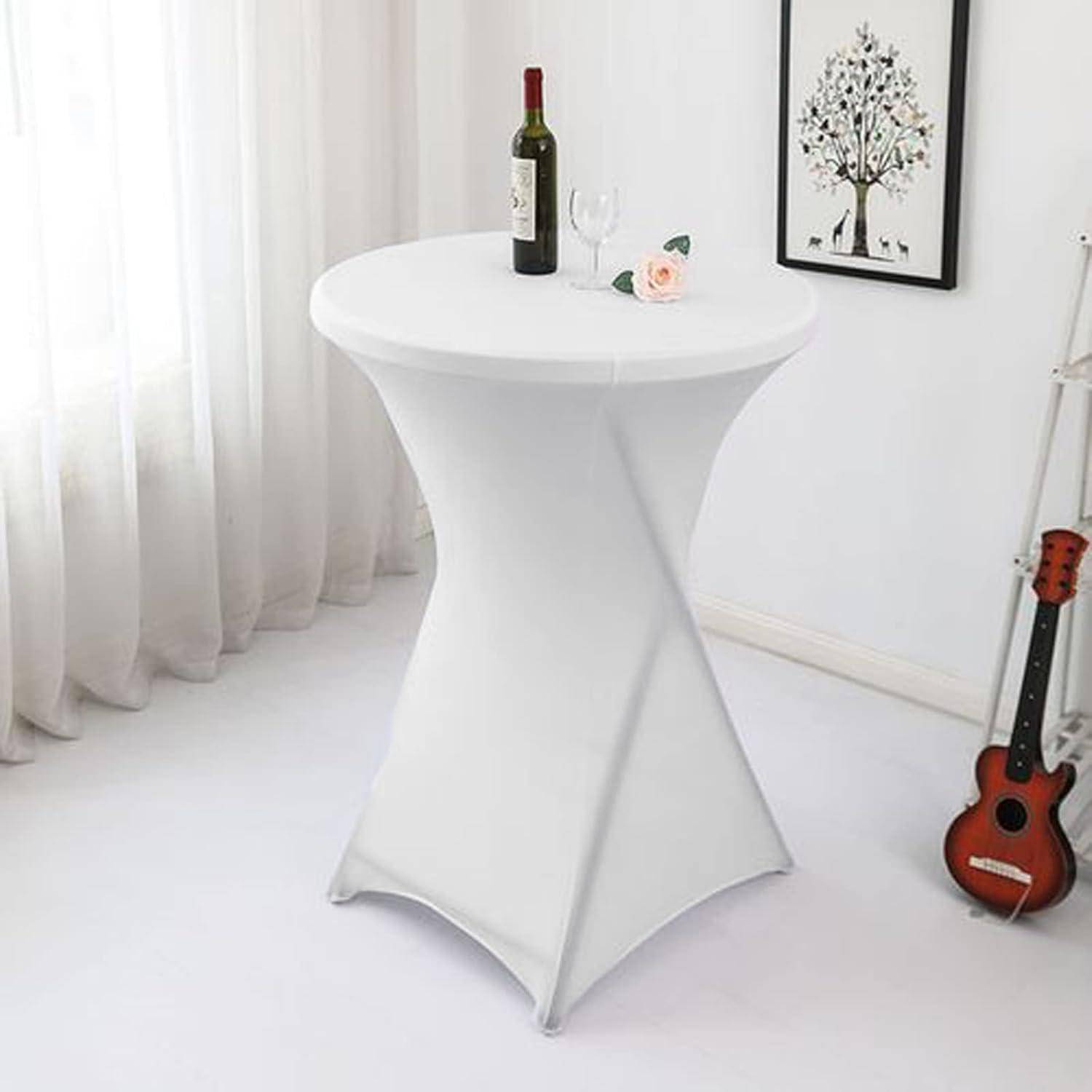 Ein weißer Cocktailtisch mit einer Weinflasche, zwei Gläsern und einem kleinen Dekorationsobjekt darauf, neben einer Gitarre und gerahmter Kunst.