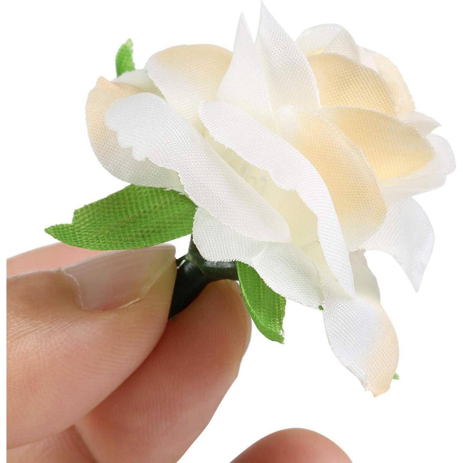 Eine Hand hält eine kleine, weiße künstliche Blume mit grünen Blättern und hebt die zarten Blütenblätter und Handwerkskunst der Kunstblume hervor.