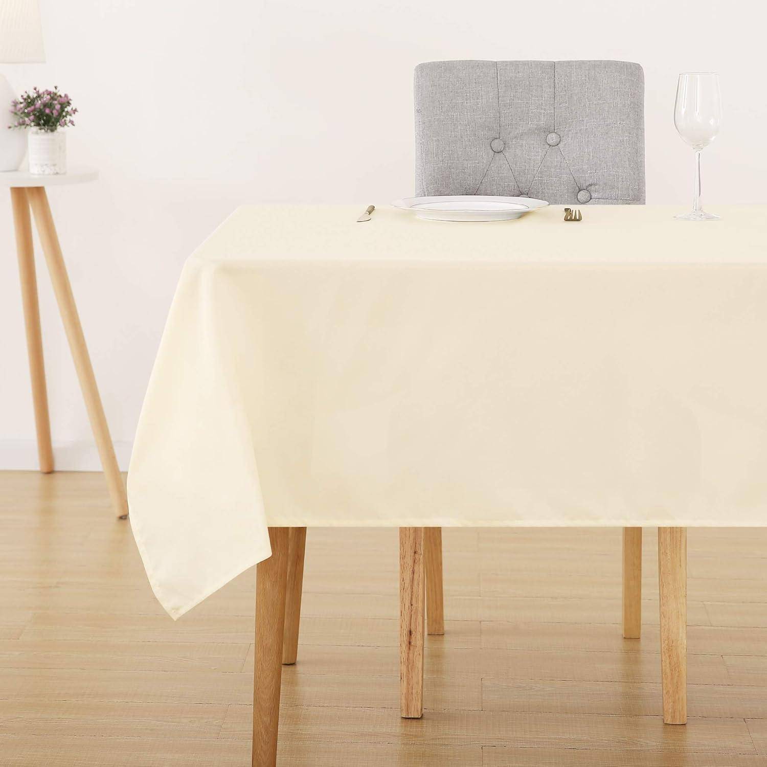 Ein Esstisch, für eine Person gedeckt, mit einer weißen Tischdecke, auf der ein Teller, Besteck und ein Weinglas platziert sind. Ein einzelner Stuhl steht dahinter.