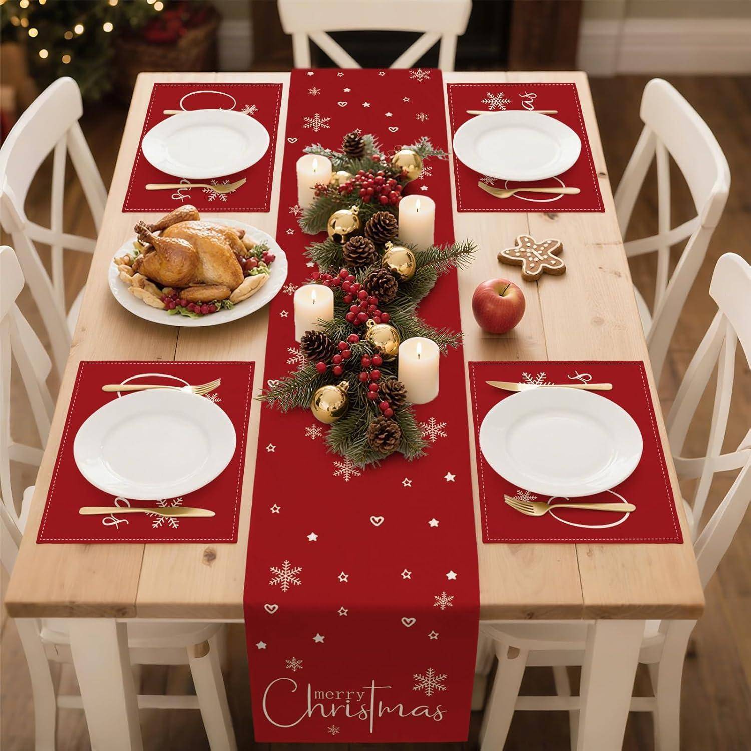 Ein festlich gedeckter Weihnachtstisch mit roten Platzsets und einem passenden Tischläufer mit der Aufschrift 