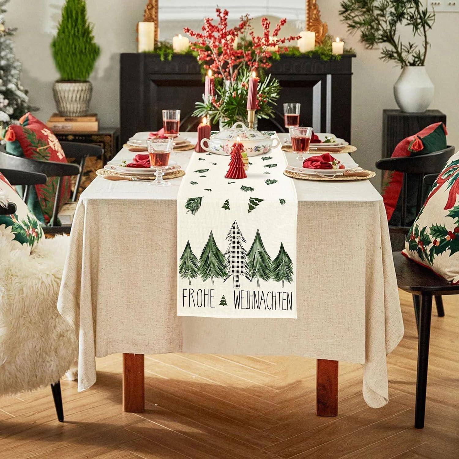 Ein Esstisch, geschmückt für Weihnachten mit einem festlichen Läufer mit Baumdesigns und den Worten ‚Frohe Weihnachten', umgeben von roten und grünen Dekorationen.