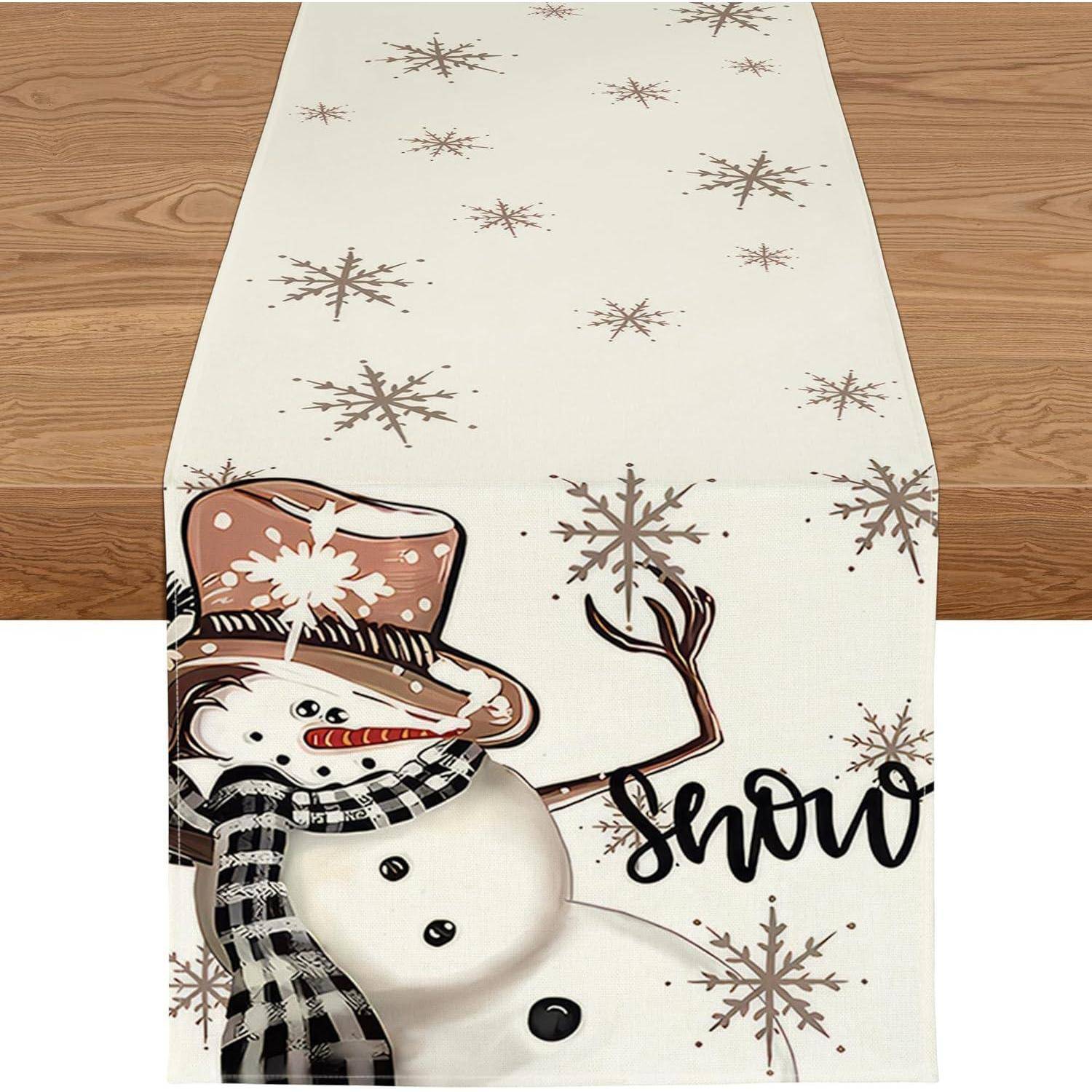 Ein festlicher Tischläufer mit einem lächelnden Schneemann mit Hut und Schal, umgeben von Schneeflocken, mit dem Wort 