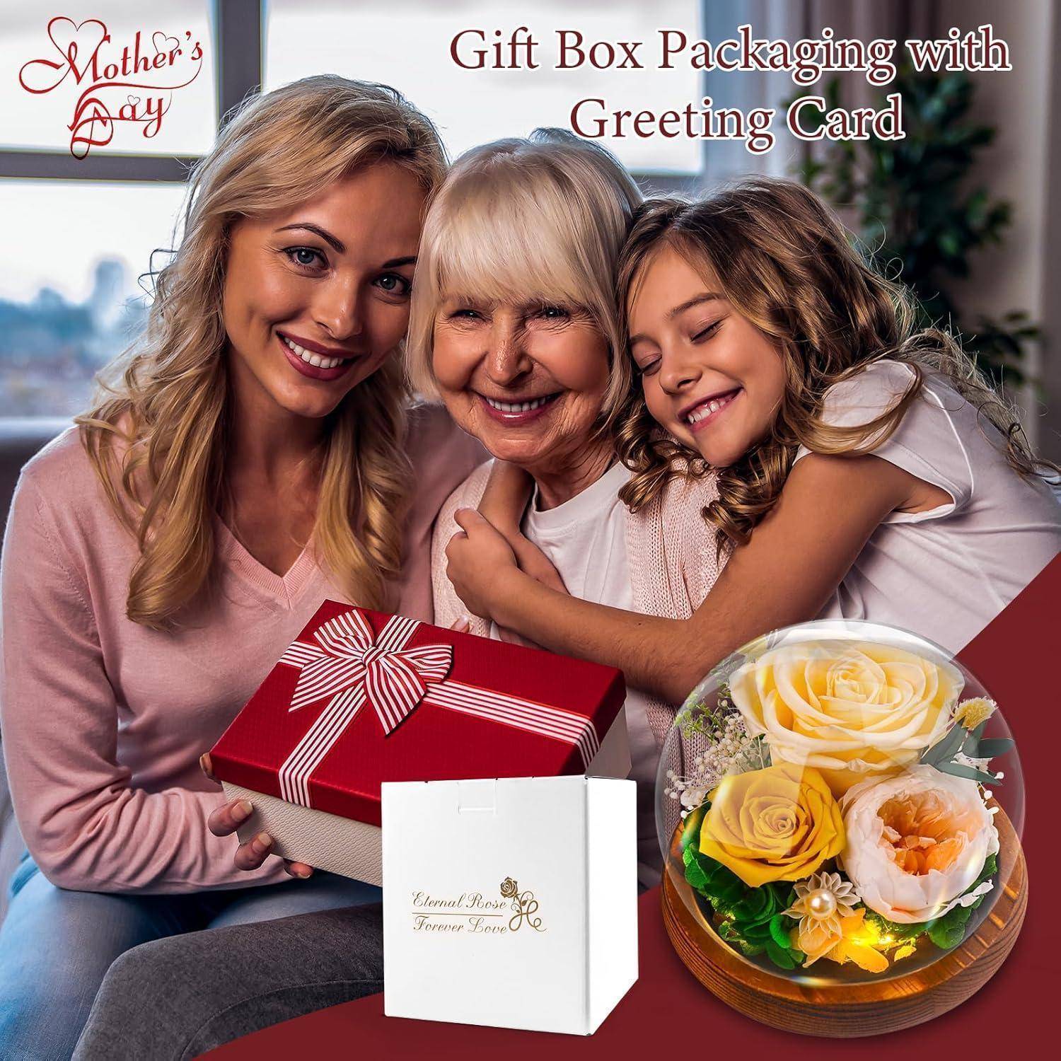 Eine lächelnde Frau, eine ältere Frau und ein Kind umarmen sich. Sie halten eine Geschenkbox, die mit einem roten Band gebunden ist. Der Text besagt „Muttertag