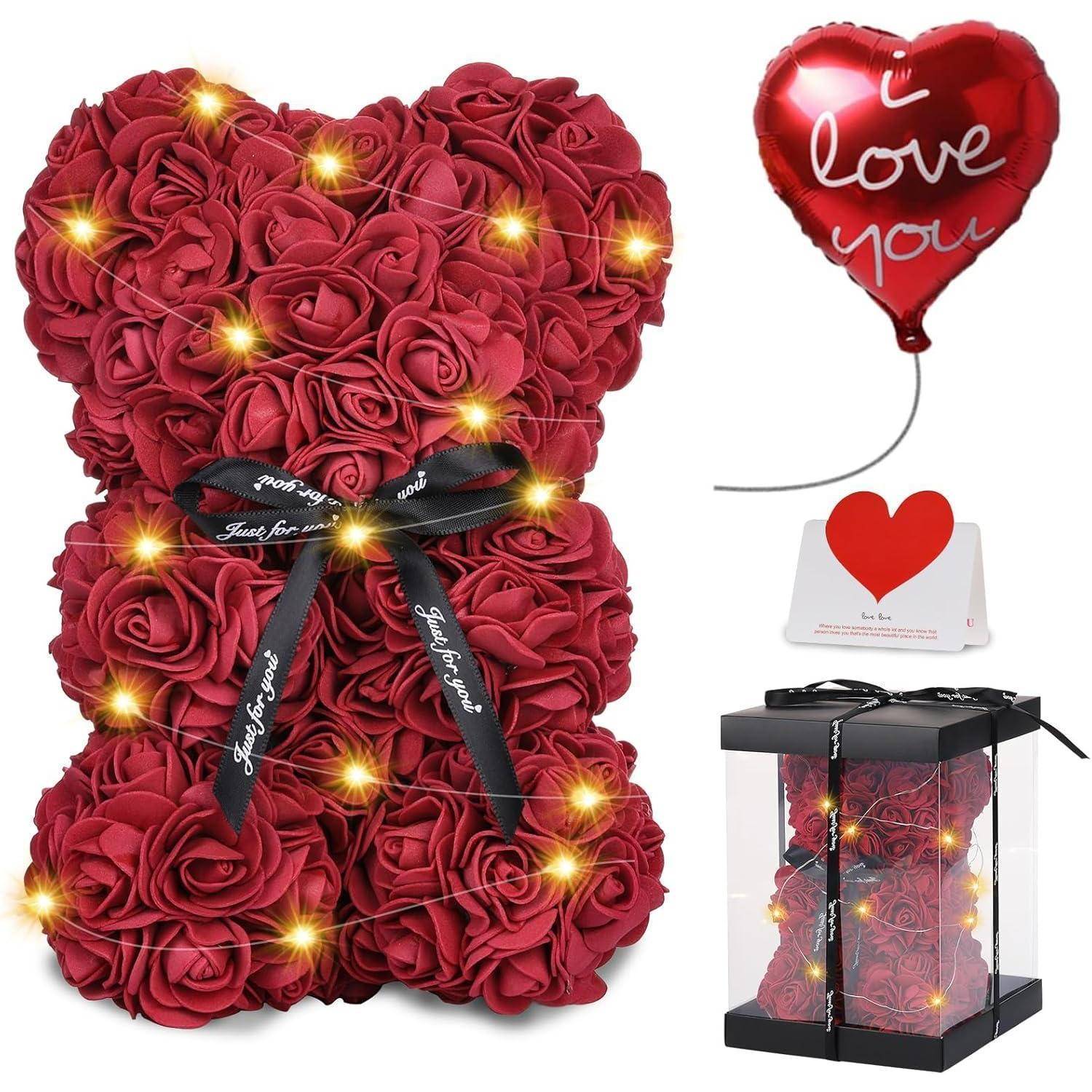 Ein Teddybär aus roten Rosen mit dekorativen Lichtern, einem Band mit der Aufschrift 