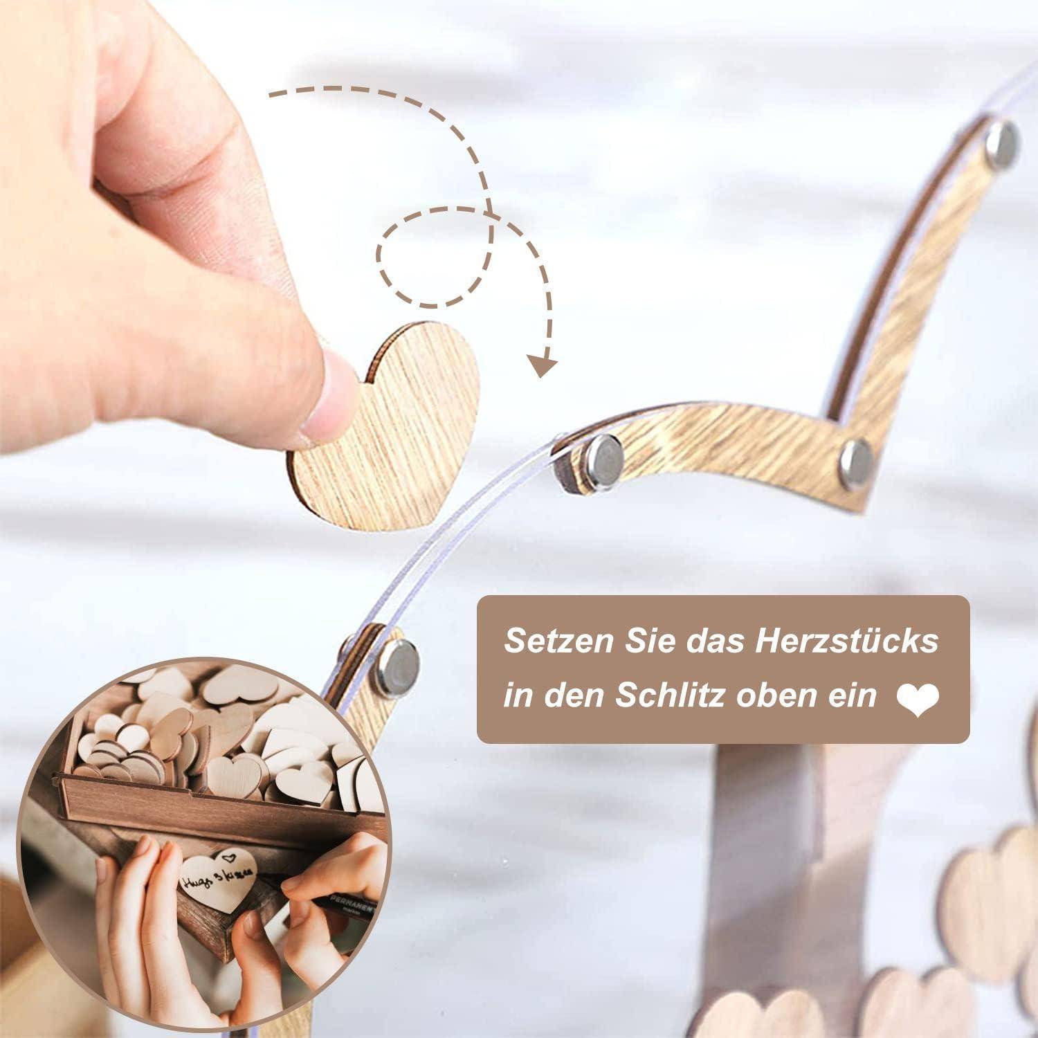 Eine Hand platziert ein Holzherz in eine Aussparung auf einem dekorativen Ständer. Ein Einschub zeigt eine Sammlung von Herzen. Der deutsche Text gibt Anweisungen zum Einsetzen des Herzens.