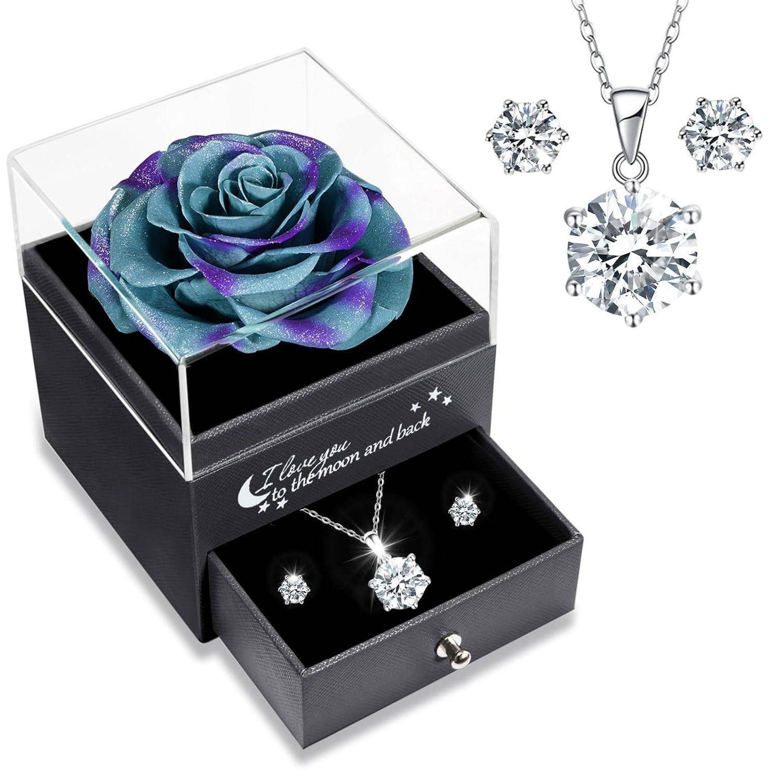 Geschenkset mit einer blau-lila Rose in einer durchsichtigen Box, Halskette und Ohrringe in einer Schublade. Aufschrift lautet: „Ich liebe dich bis zum Mond und zurück
