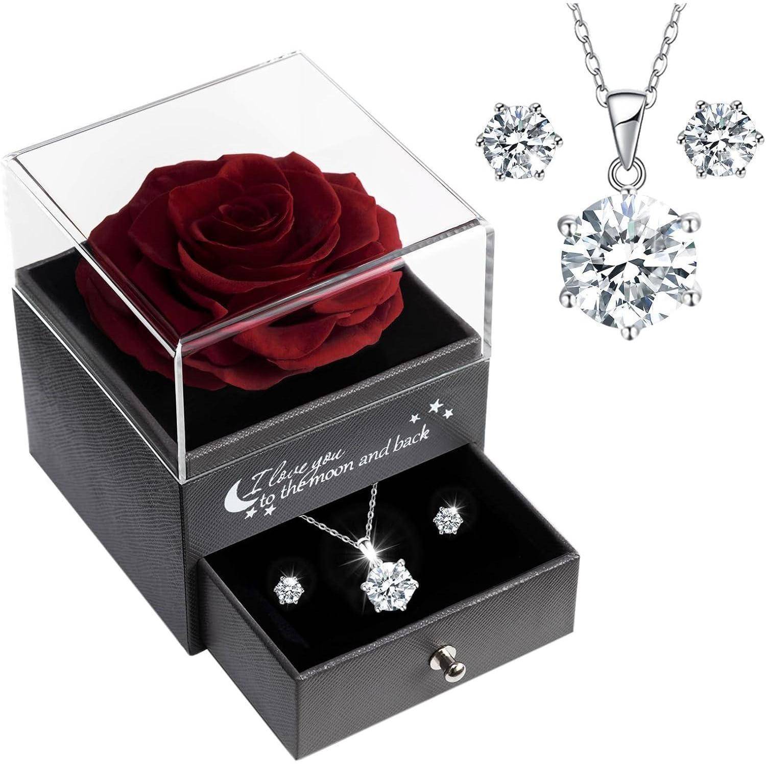 Eine schwarze Geschenkbox mit einer roten Rose sowie einer Halskette und Ohrringe. Auf der Box ist der Text ‚Ich liebe dich bis zum Mond und zurück' eingraviert.