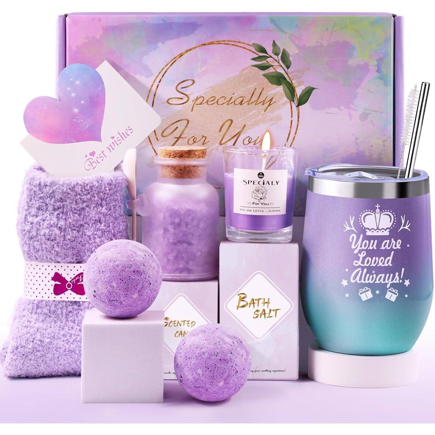 Geschenkbox mit pastellviolettem Thema, die eine Kerze, eine Keramiktasse mit der Aufschrift ‚Du bist immer geliebt', Badesalz, zwei Badebomben, ein zusammengerolltes Handtuch und eine herzförmige Karte mit der Aufschrift ‚Beste Wünsche' enthält.