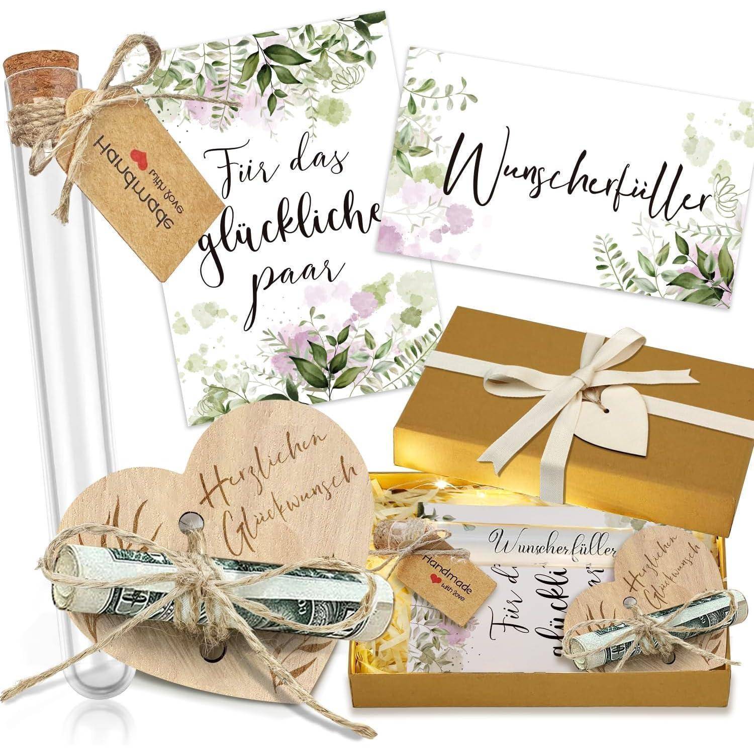 Ein dekoratives Geschenkset mit zwei Karten in Blumendesign mit den Aufschriften ‚Für das glückliche Paar' und ‚Wunscherfüller', einer goldenen Box und einem Holzherz.