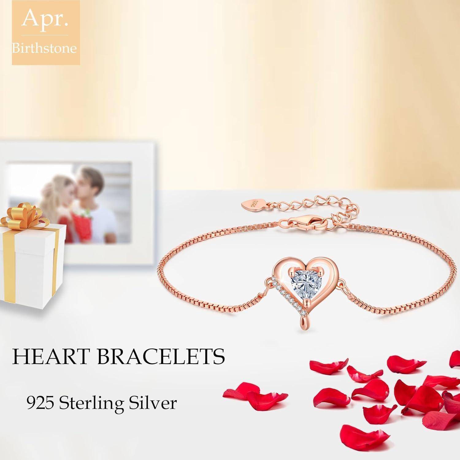 Silbernes Herz-Armband mit einem zentralen Edelstein, umgeben von einer Geschenkbox, einem Foto und roten Blütenblättern. Text lautet: 'HERZ-ARMBÄNDER 925 Sterling Silber'.