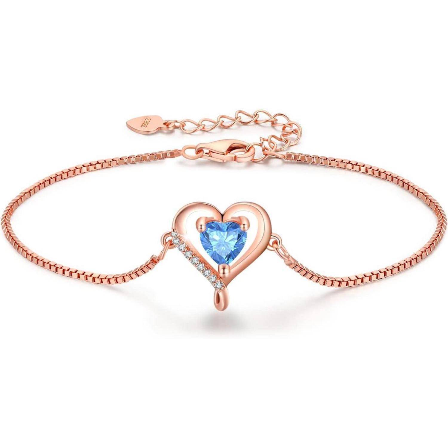 Ein Roségold-Armband mit herzförmigem Design, einem blauen Edelstein als Mittelpunkt und kleinen weißen Steinen, verbunden durch eine zarte Kette.