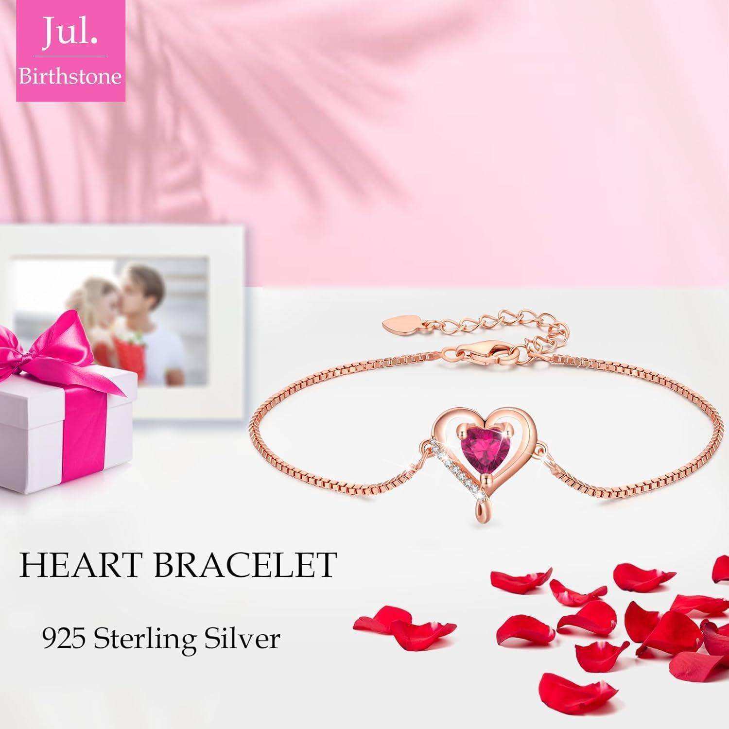 Herzarmband mit rosa Edelstein, Rosenblütenblättern und rosa Geschenkbox im Hintergrund. Text lautet: 'Herzarmband aus 925er Sterlingsilber'.