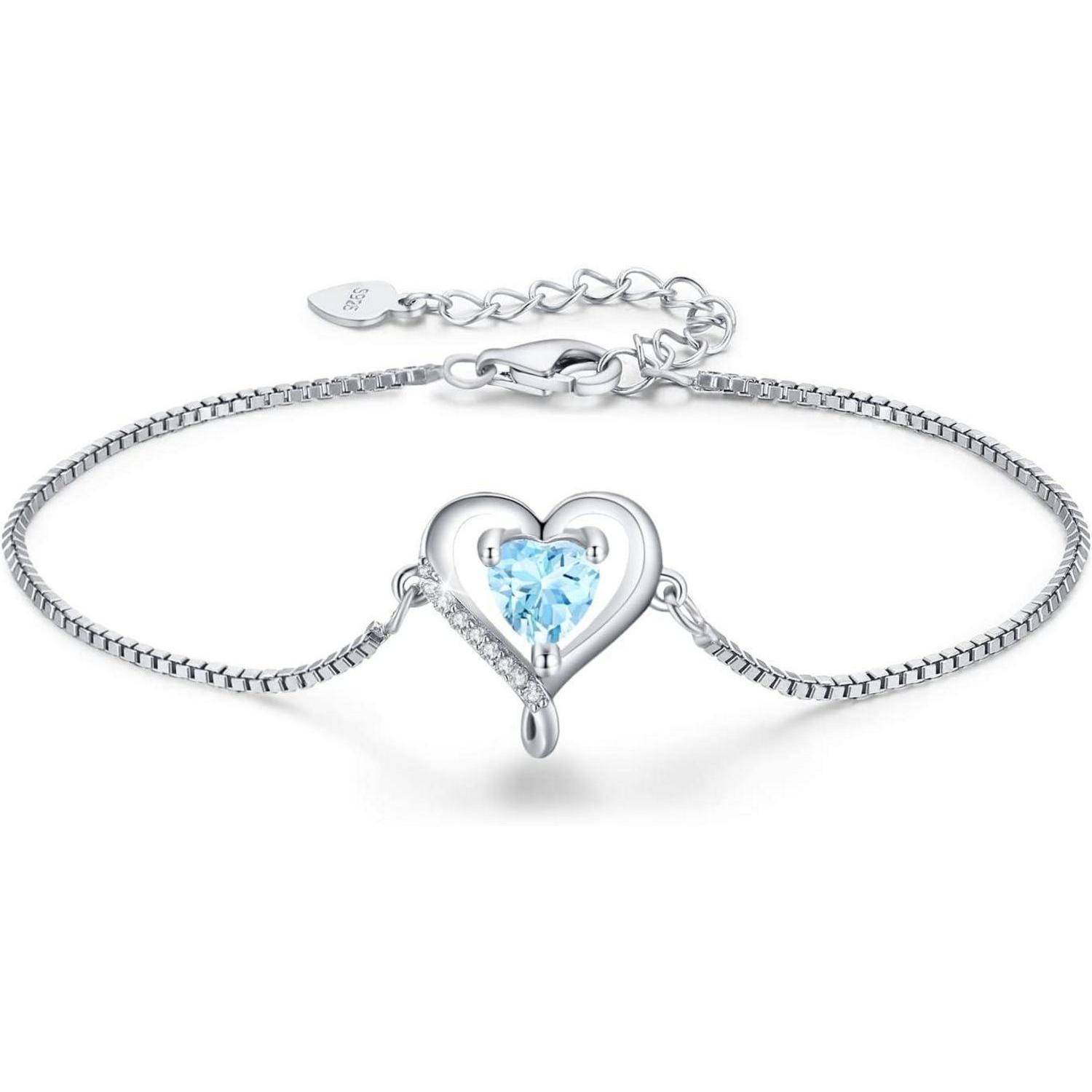 Ein Silberarmband mit einem herz-förmigen blauen Edelstein in der Mitte, ausgestattet mit einem verstellbaren Verschluss für Größenvariation.