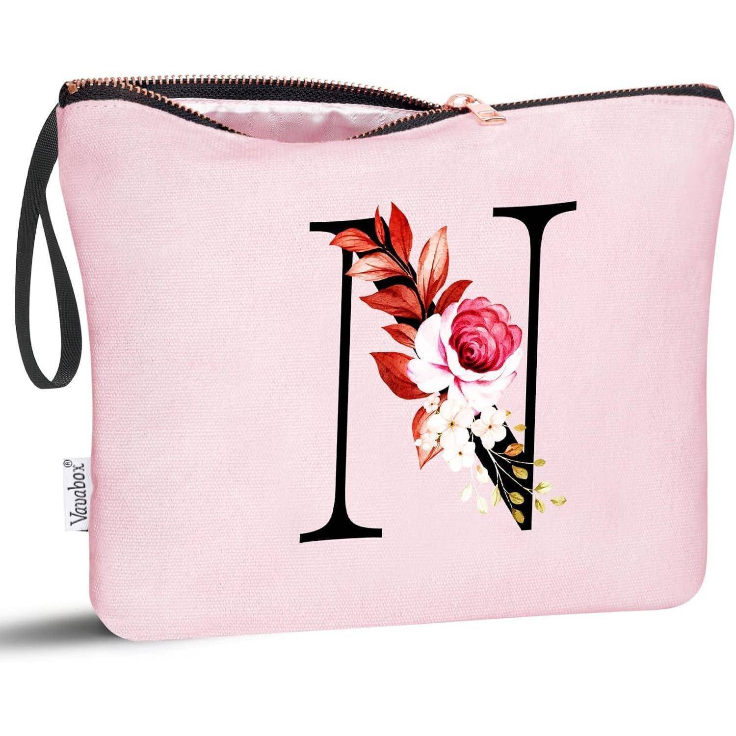 Ein rosa Beutel mit dem Buchstaben 'N' und floraler Verzierung.