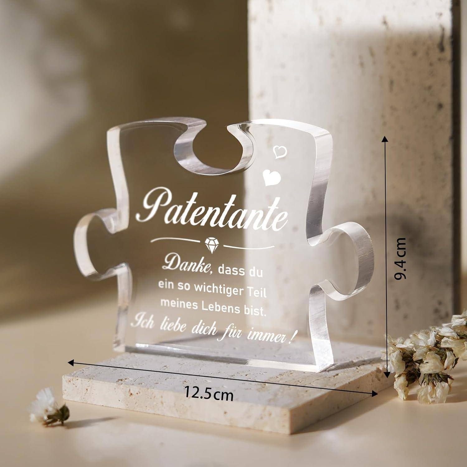 Glasspuzzleteil auf Marmorbase mit Text 'Patentante'. Begleitet von Blumen, Maße angegeben: Höhe 9,4 cm, Breite 12,5 cm.