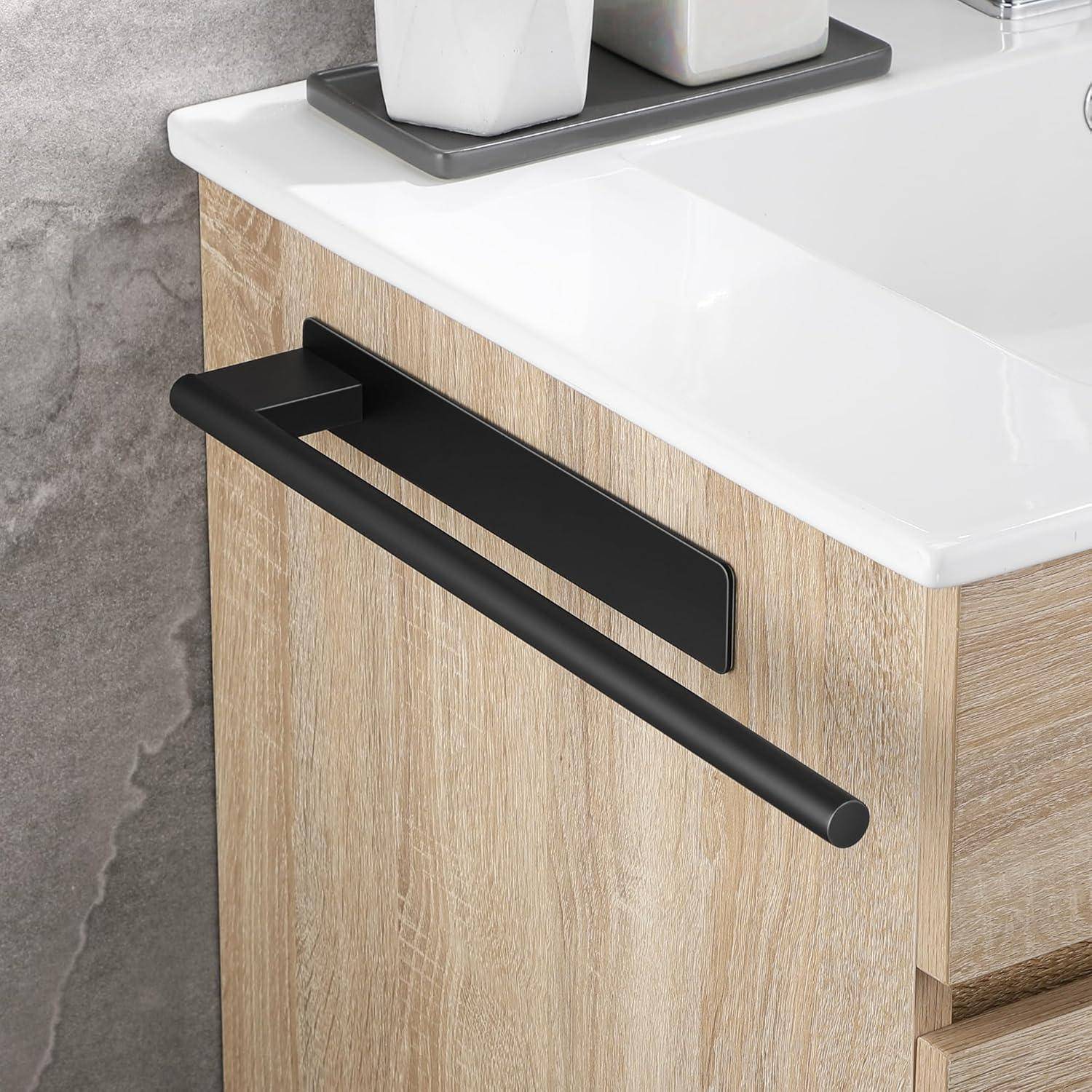 Weißes Waschbecken mit einem hellholzfarbenen Schrank und einer schwarzen Handtuchstange. Zwei weiße geometrische Behälter stehen auf der Arbeitsplatte.