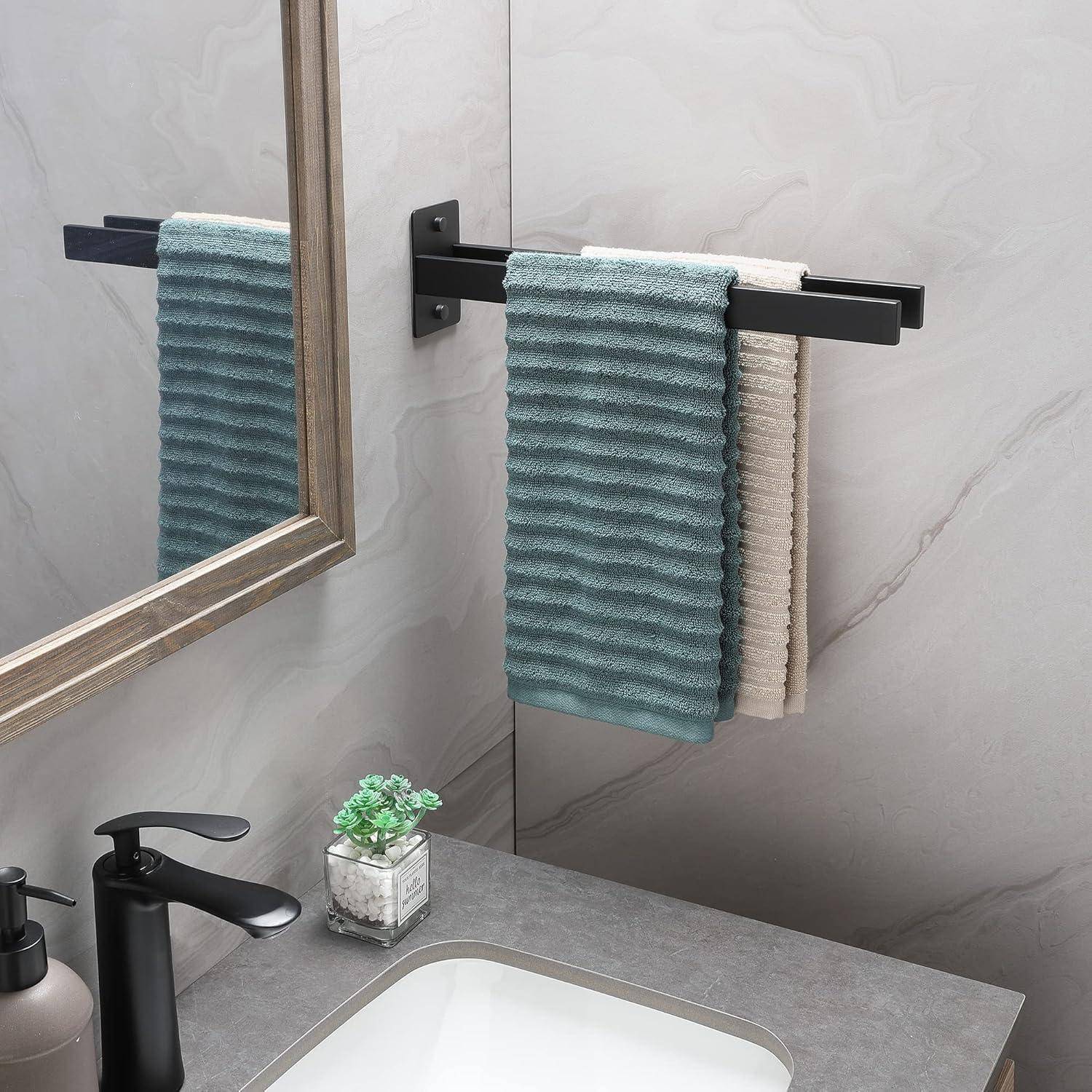 Ein modernes Badezimmerwaschbecken verfügt über eine graue Arbeitsplatte mit einem schwarzen Wasserhahn. Ein Spiegel reflektiert türkis- und beigefarbe Handtücher, die an einem Handtuchhalter hängen.