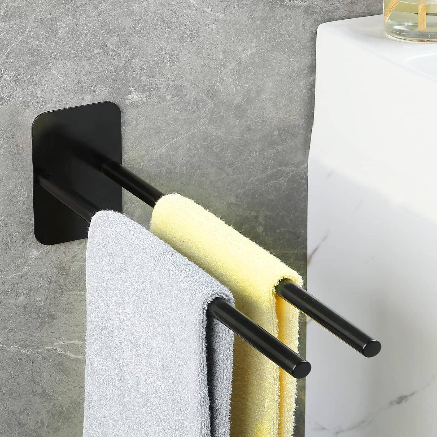 Ein Badezimmer mit grauen und gelben Handtüchern, die an einem schwarzen Doppel-Handtuchhalter an einer grauen Wand neben einem weißen Waschbecken hängen.