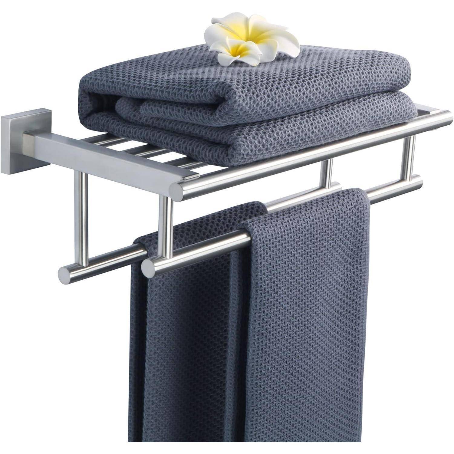 Ein grauer Handtuchhalter trägt gefaltete Handtücher mit einer Plumeria-Blüte obenauf; darunter hängt ein Handtuch.