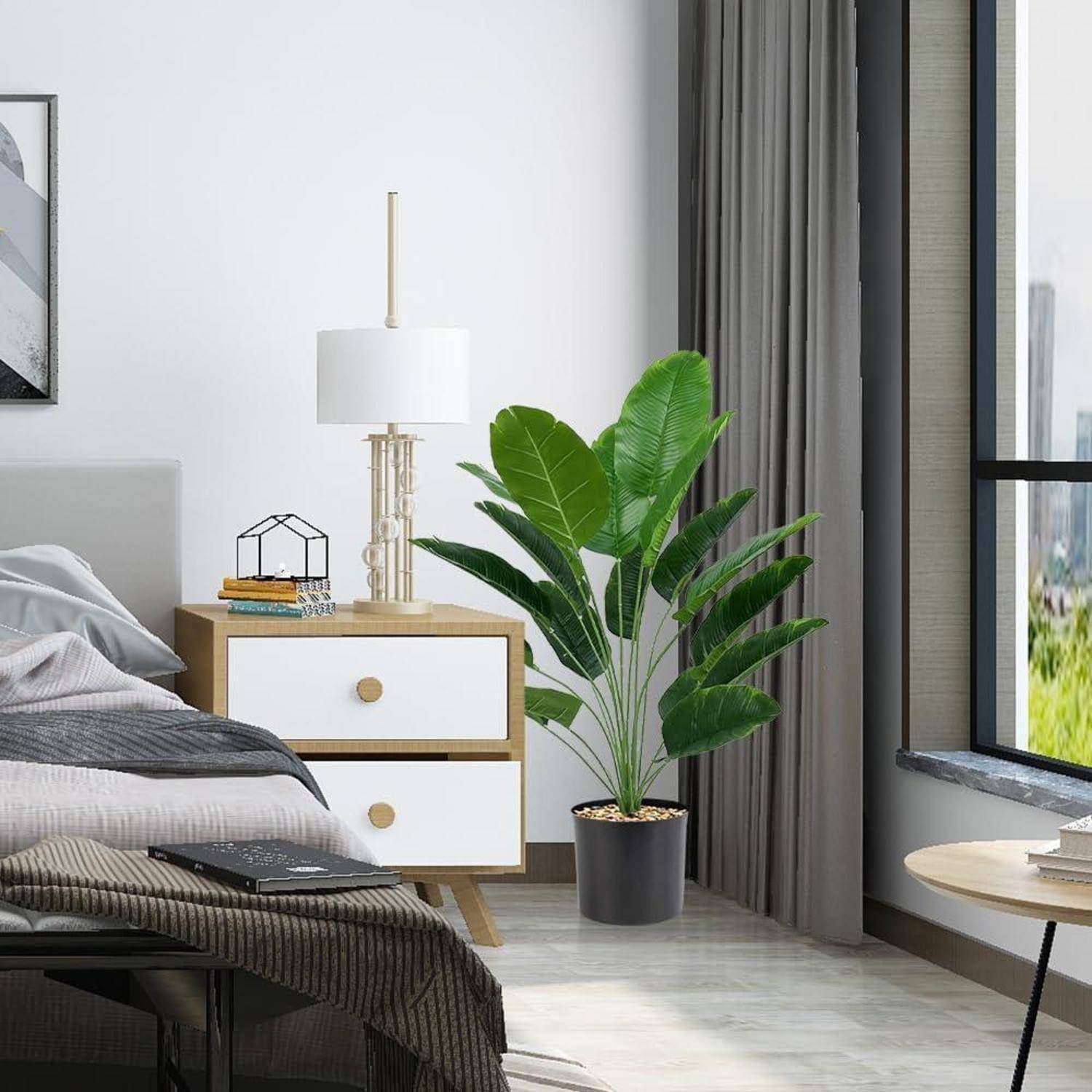 Ein modernes Schlafzimmer mit einem ordentlich gemachten Bett, einem Holznachttisch mit einer Lampe und Büchern sowie einer großen grünen Pflanze neben einem bodentiefen Fenster.