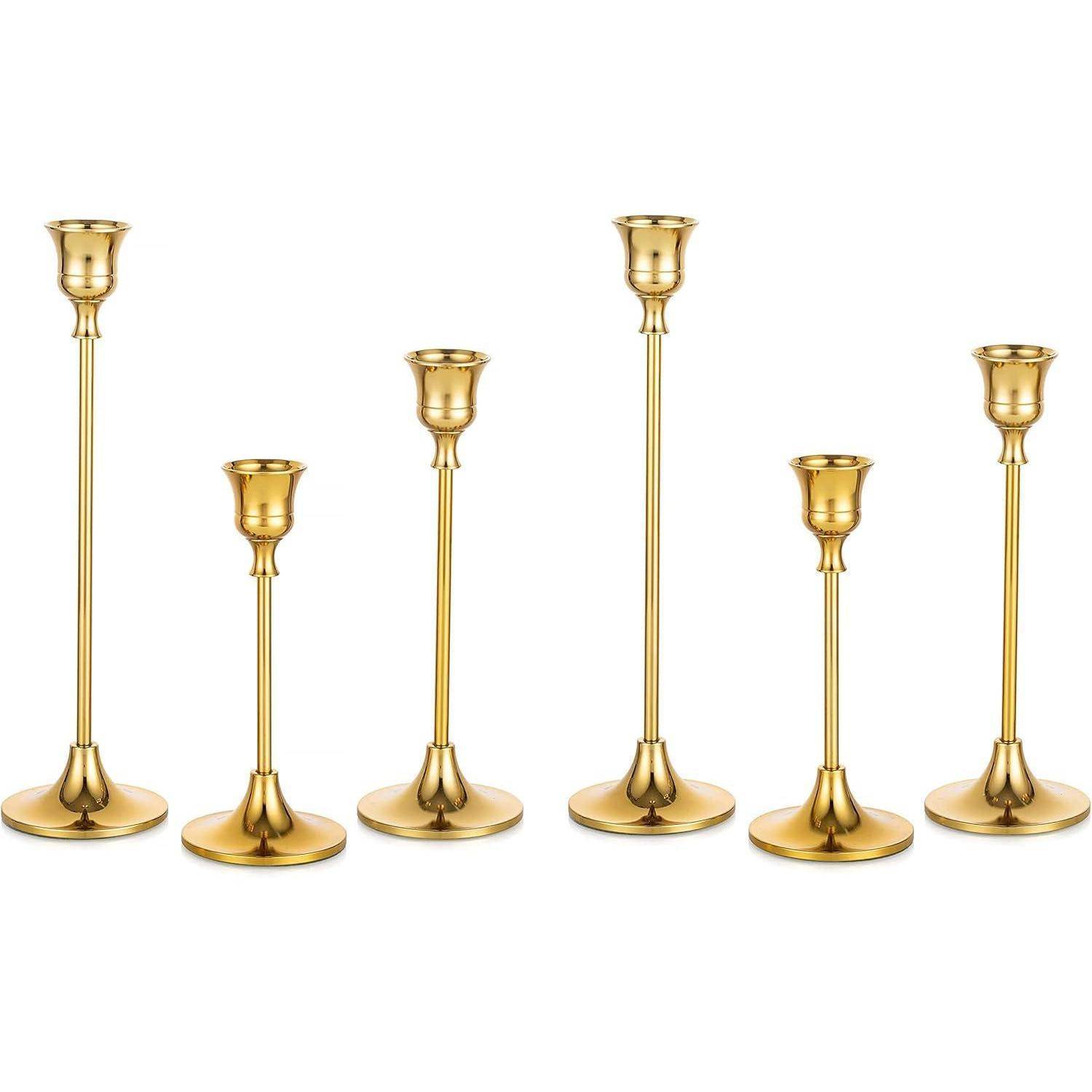 Ein Set aus sechs goldenen Kerzenhaltern unterschiedlicher Höhen, die in einer Reihe angeordnet sind und ein schlankes, minimalistisches Design mit runden Böden aufweisen.