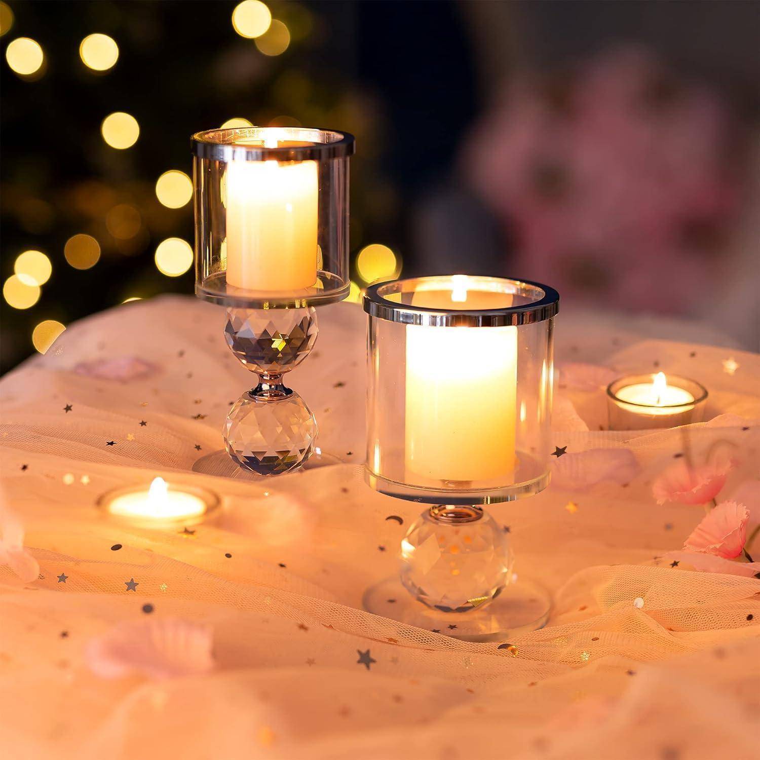Zwei angezündete Kerzen in Glashaltern auf einem dekorierten Tisch mit rosa Stoff und sternförmigem Konfetti, weich fokussierte Lichter im Hintergrund.